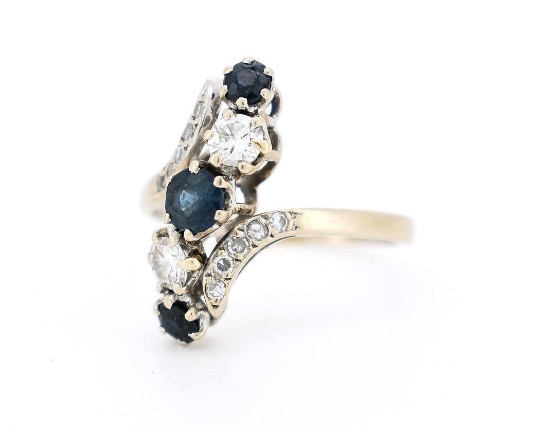 Vintage Belle Époque-style ring in 18K gold (750/1000) from the 1960s. It features a central row alternating three sapphires, totaling approximately 0.50 carat, and two diamonds, totaling 0.30 carat. The motif is accented by a pavé of brilliant-cut