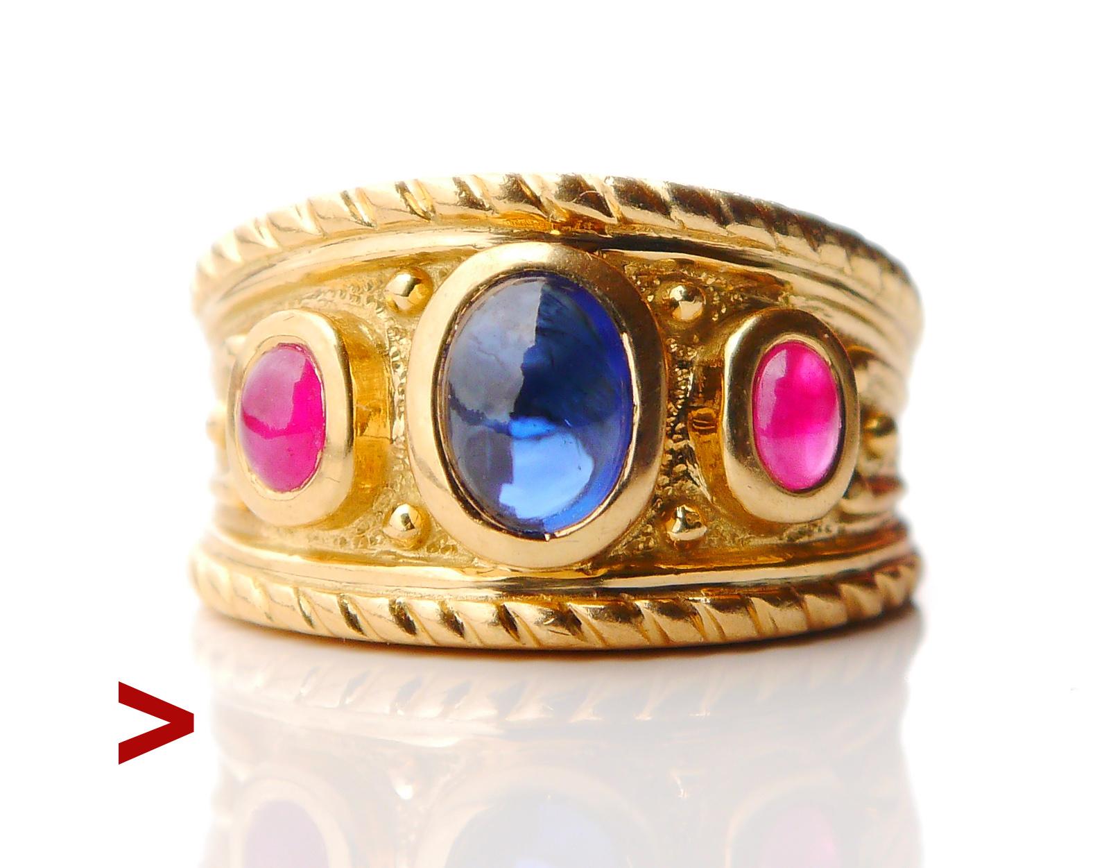 Anello vintage con tre pietre in oro giallo massiccio 18 carati. Questo design ricorda gli antichi pezzi del periodo romano/bizantino, con spalle intagliate e un'ampia corona decorata con gemme, qui con zaffiro blu naturale e rubini naturali. Questo