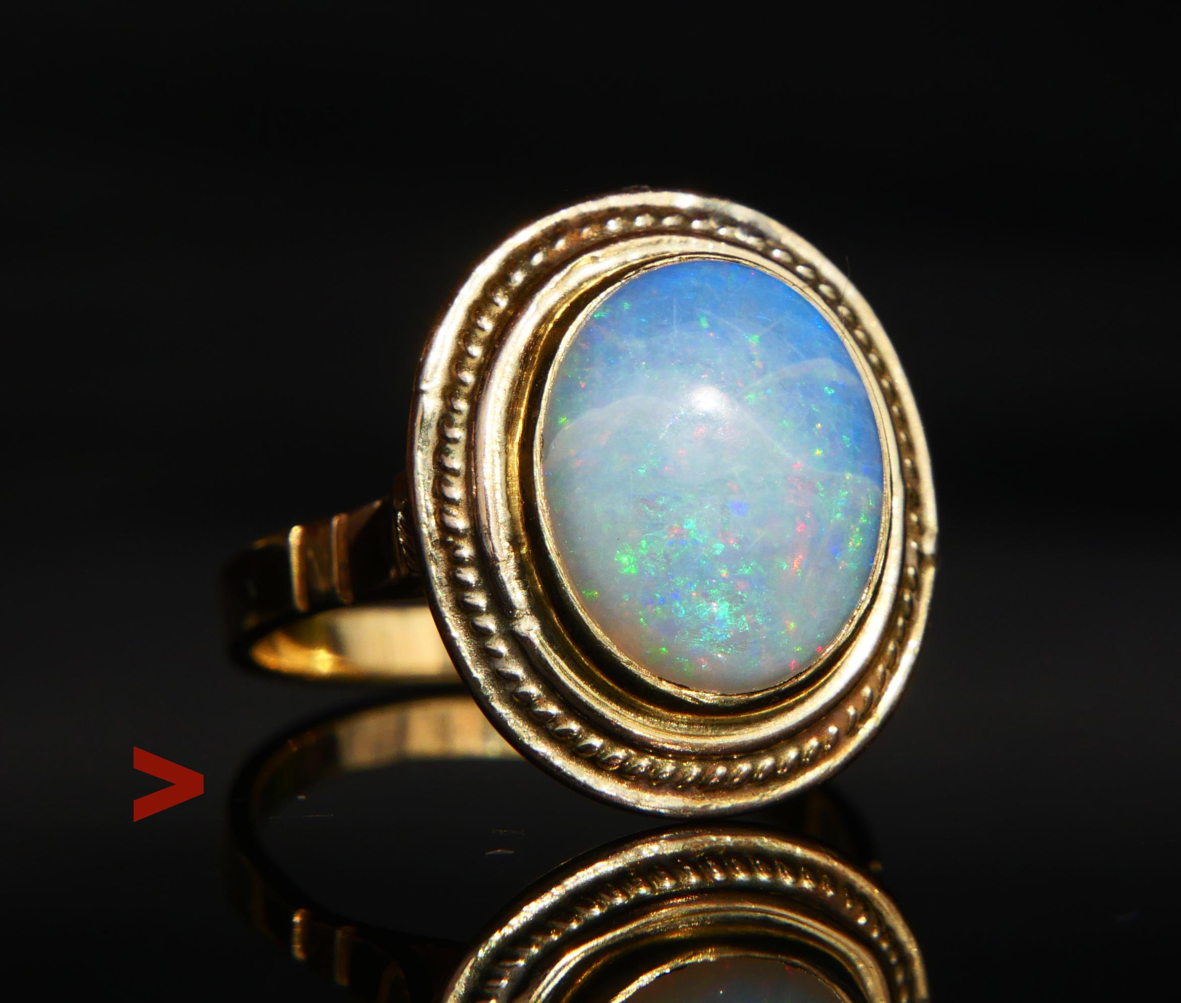 Vintage Ring decorated with bezel set oval cut cabochon of natural Opal stone Ø 12 x 10 mm x 5.25 mm deep, ca. 5 ct . Stone with natural flows inside, shows multicolored effects often differently in various light conditions. Crown is 17 x 15 x 10 mm
