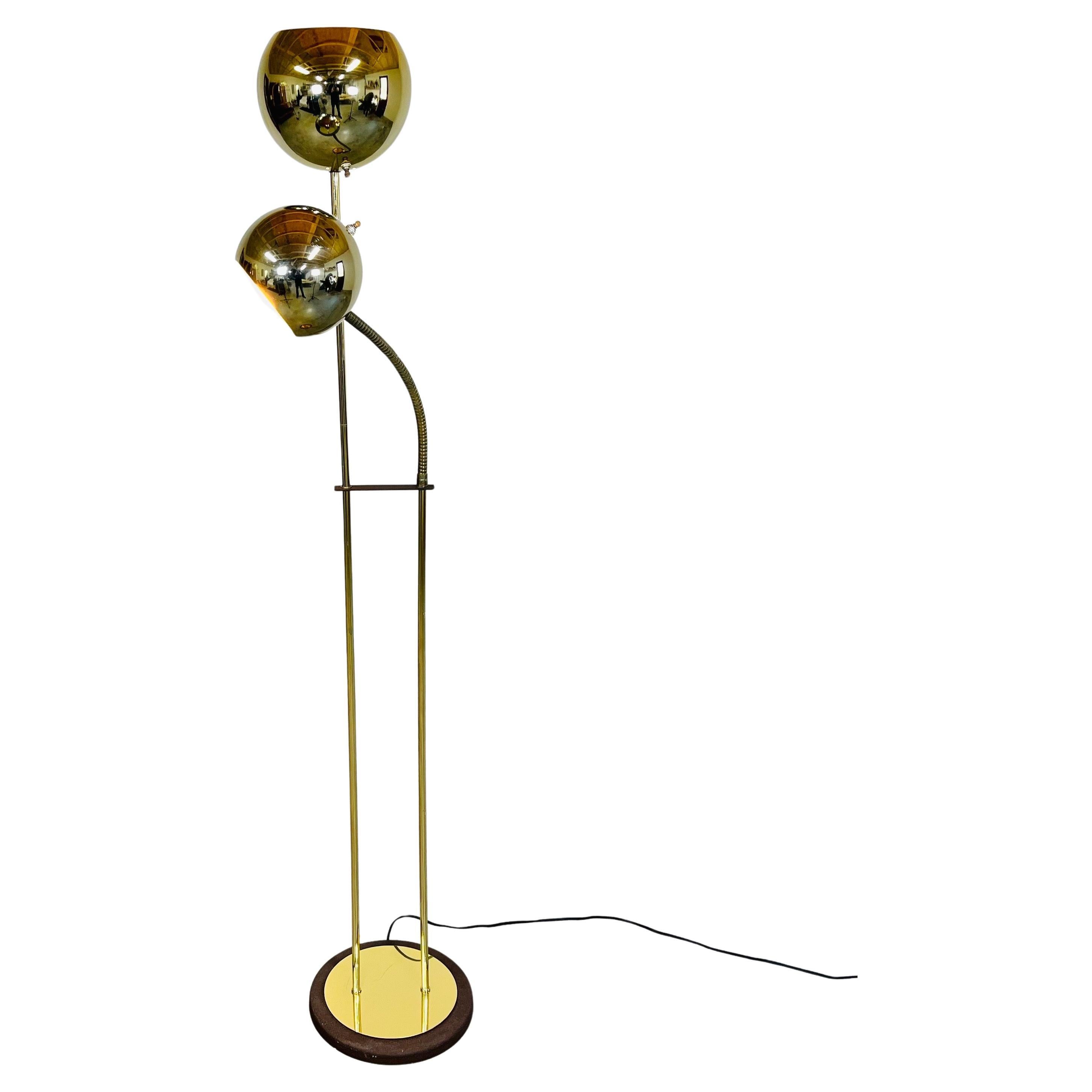 Mid-century double orb brass floor lamp having an adjustable reading light in the manner of Robert Sonneman. United States circa 1960. 
In great vintage condition having minor signs of usage. Each light features its own on/off switch. 
61x20x12” HWD