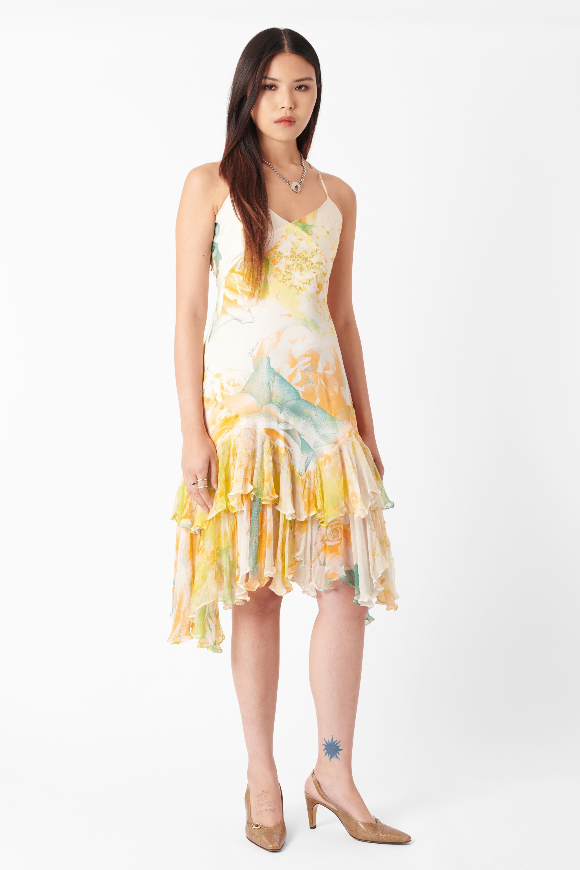 Vestido midi vintage Roberto Cavalli 2004 de seda amarilla estampada. Presenta cuerpo de seda con tirantes finos, espalda deportiva con detalles de herrajes plateados y volantes semitransparentes en el bajo de largo midi con cierre de cremallera