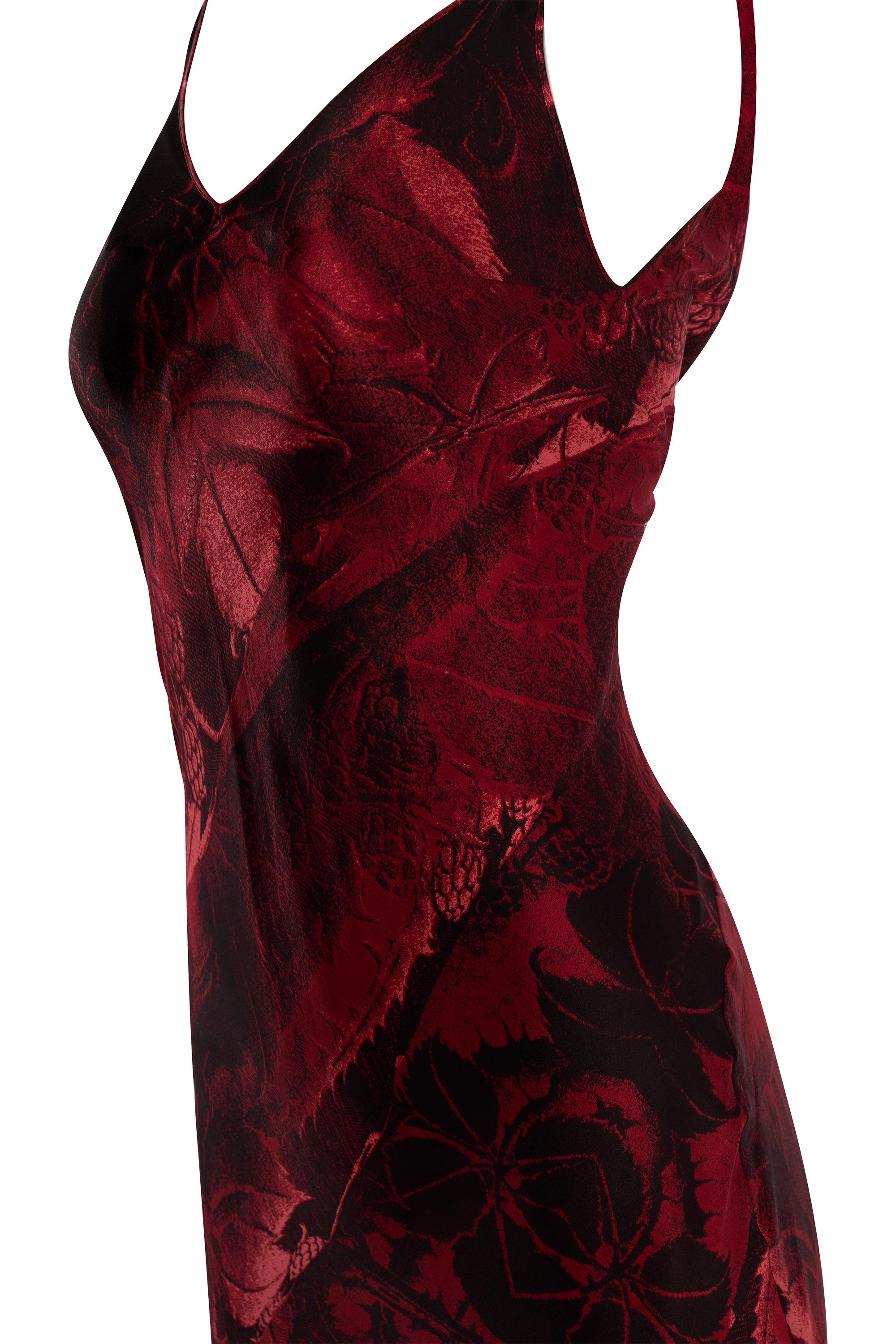 Abito da sera lungo fino al pavimento in seta rossa di Roberto Cavalli della collezione autunno-inverno 2000. Caratterizzato da una stampa fotografica astratta rossa e nera, un taglio sbieco, schiena bassa con gonna a ruota drappeggiata lunga fino