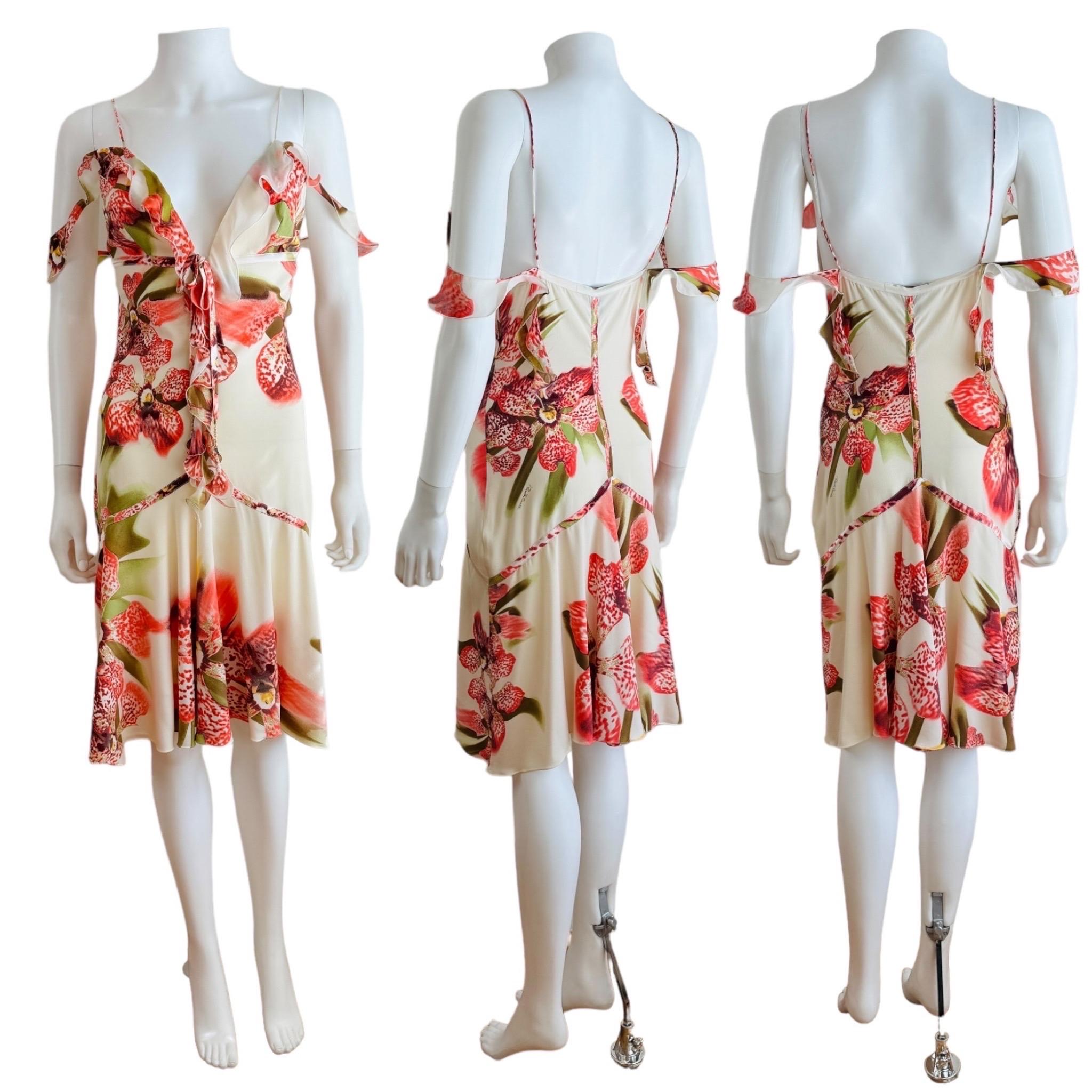 Vintage F/W 2004 Roberto Cavalli Dress
Cream/off white silk fabric with oversized pink tiger orchid print throughout
Gold glitter accents on fabric
Deep v neckline with ruffle trim + ties at the bust with metal chains + charms at the end
Thin