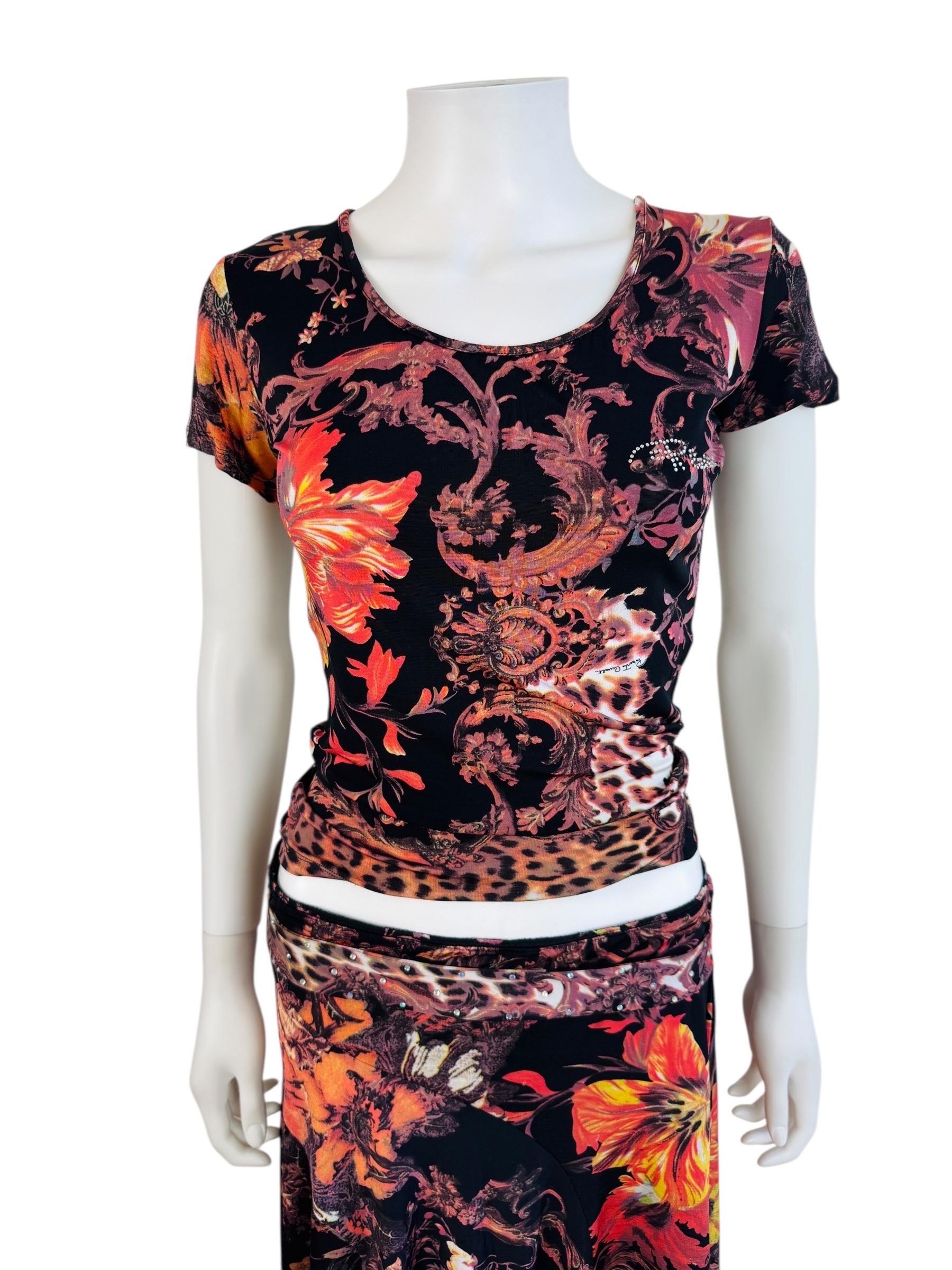 Roberto Cavalli - Top + jupe F/H 2005
Tissu lycra oversize imprimé fleurs, léopard + volutes baroques
Top à encolure dégagée
Style ajusté
Manches courtes
R Cavalli en strass sur le buste gauche

Jupe à taille élastique
Fausse ceinture sur le devant