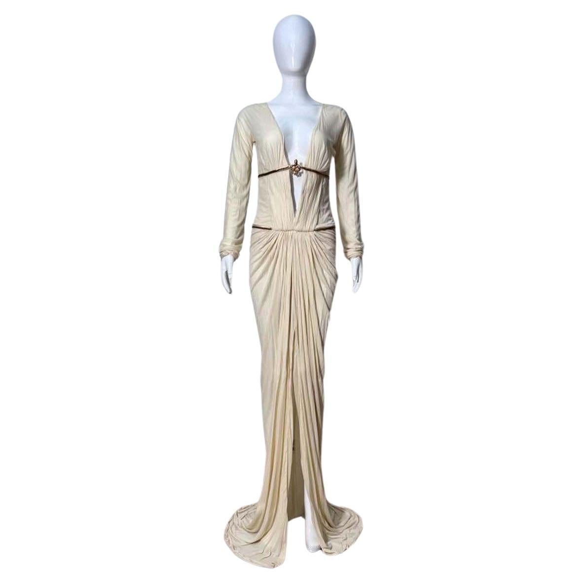 Vintage Roberto Cavalli from the fall winter 2007 collection.
Features a drape with a plunging neckline.  eggshell silk with antique gold metal serpent ornament . Further enhanced by two  antique gold metal wishbone chains encircle bodice. 
Back