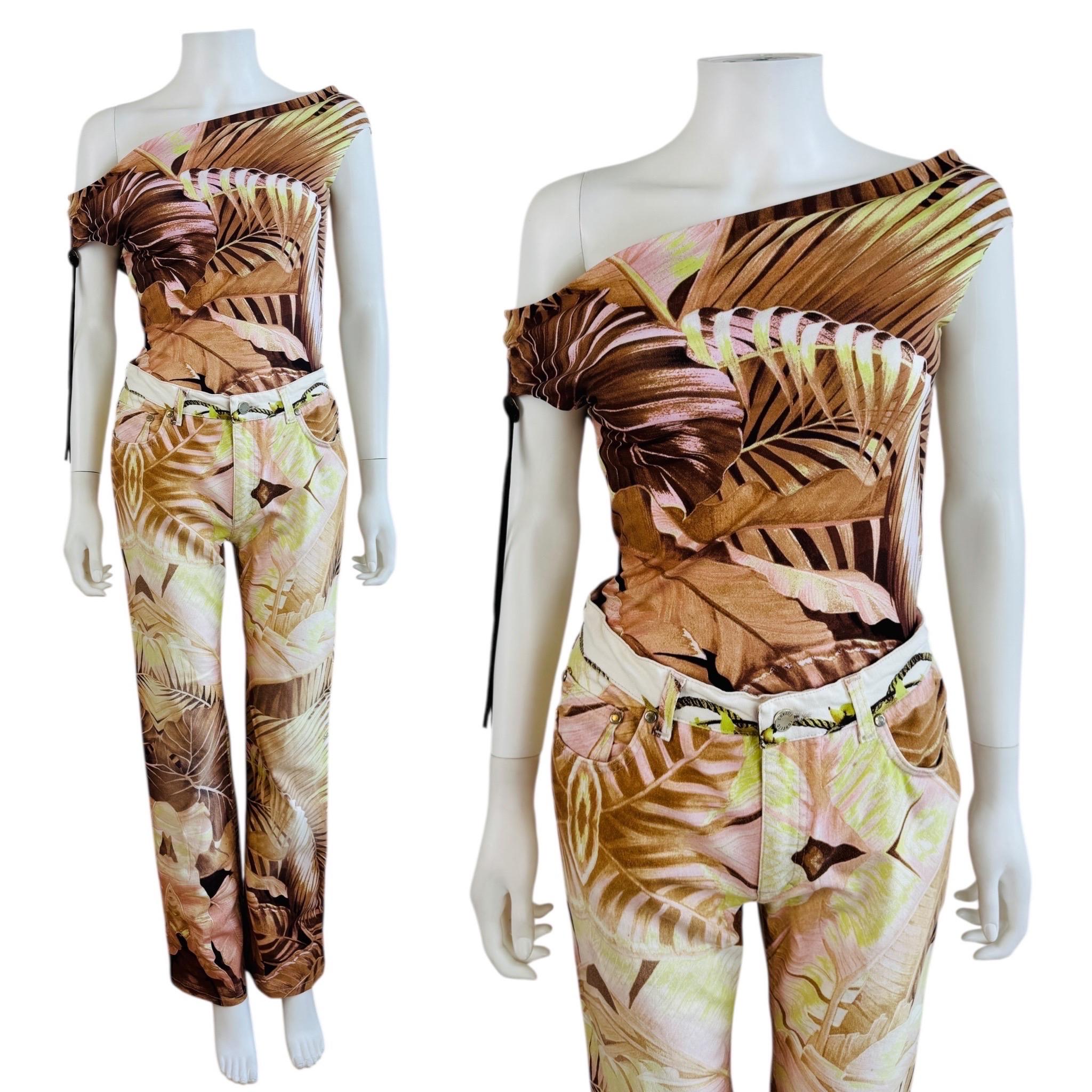 Roberto Cavalli - Top + Pantaloni P/E 2003
Stampa di palme tropicali oversize
Fabrice + tessuto elastico
Il top asimmetrico può essere indossato su una o entrambe le spalle.
Camoscio sintetico + dettaglio concho in metallo sulla spalla destra
Il top