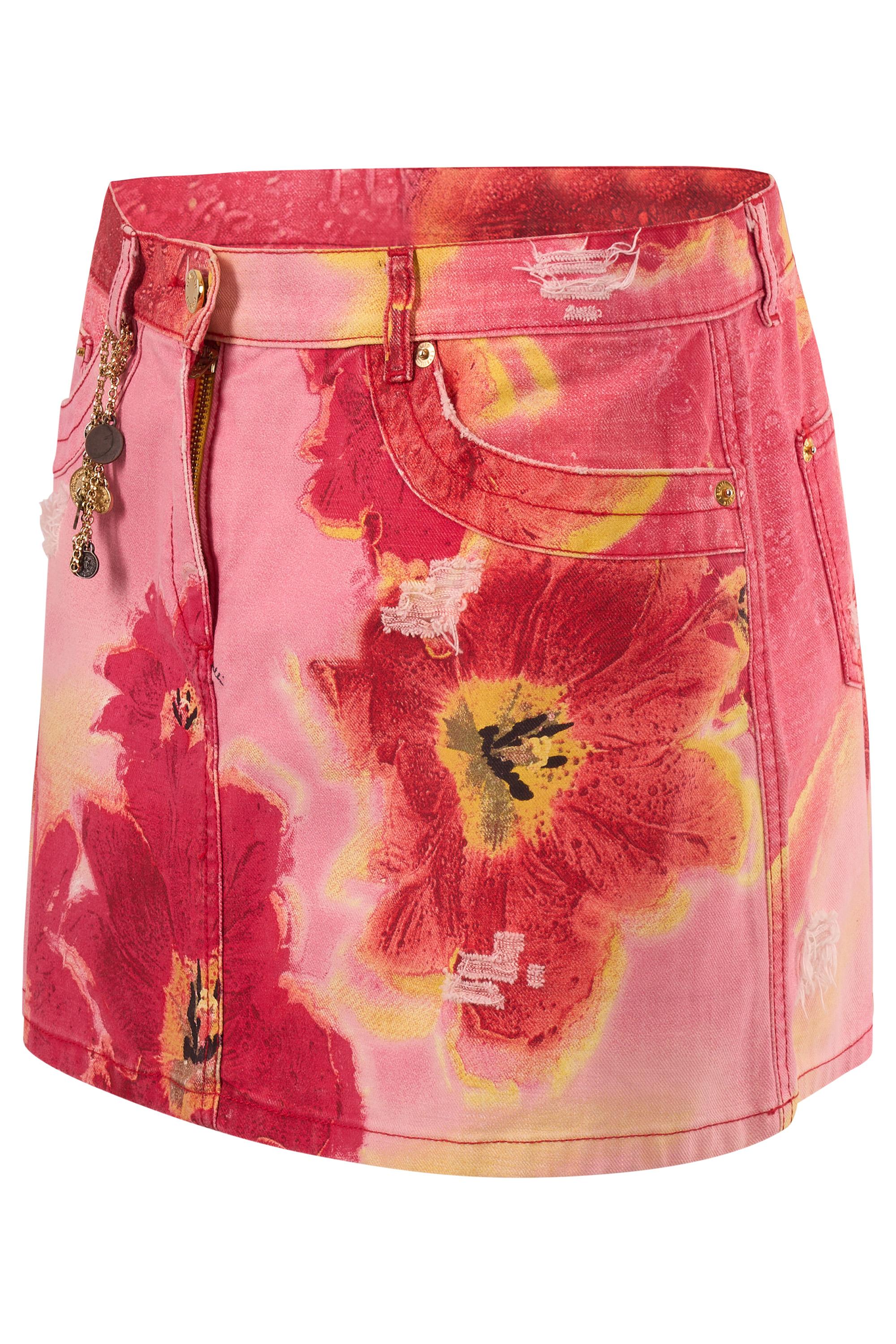 Mini gonna floreale vintage Roberto Cavalli primavera estate 2004. Presenta una base in denim con una stampa floreale in toni saturi di rosso, rosa e giallo. Dettagli rovinati, catena con charm di monete in oro.  Rifiniti con un classico stile a