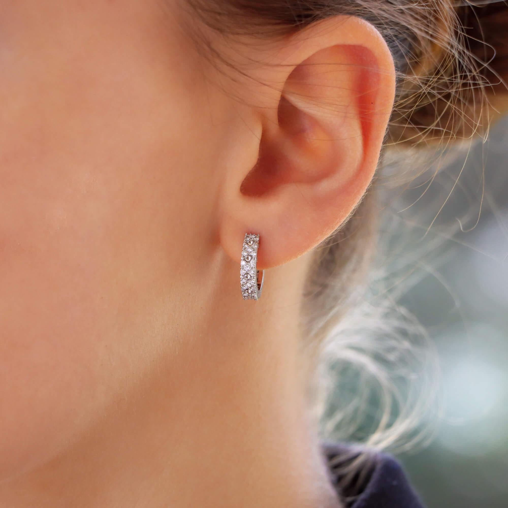 A stylish pair of vintage Roberto Coin diamond hoop earrings set in 18k white gold.

The earrings are pave set with round brilliant cut diamonds to the front and embossed with circle motifs throughout. The hoops are secured with a post and hinge