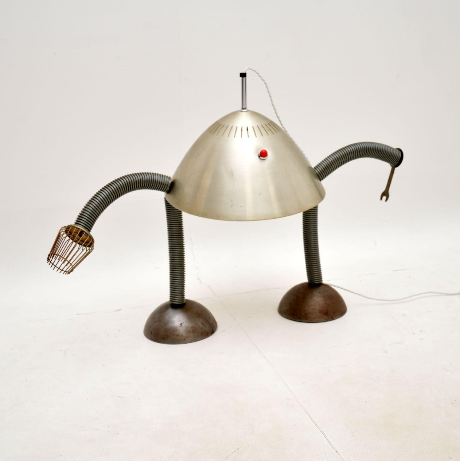 Une lampe de table robot vintage unique et très inhabituelle. Il a été fabriqué à la main par un artisan dans les années 1960-70.

Quelqu'un l'a fabriqué chez lui à partir de pièces d'objets ménagers, notamment un bouchon de radiateur Pifco pour la