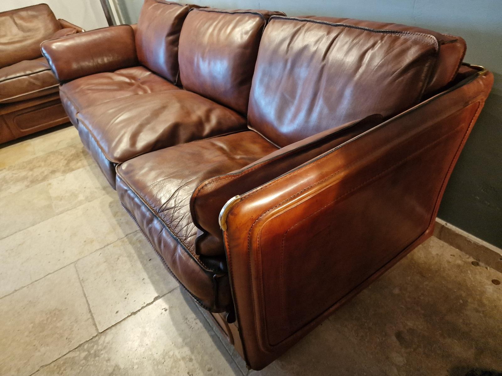 Roche Bobois 3-seater sofa in thick buffalo leather and goose feather, brass corners.  Circa 1970
 Also vailable in a pair.  In very good shape.
 Price per sofa
 (2-seater sofas and armchair model also available.)