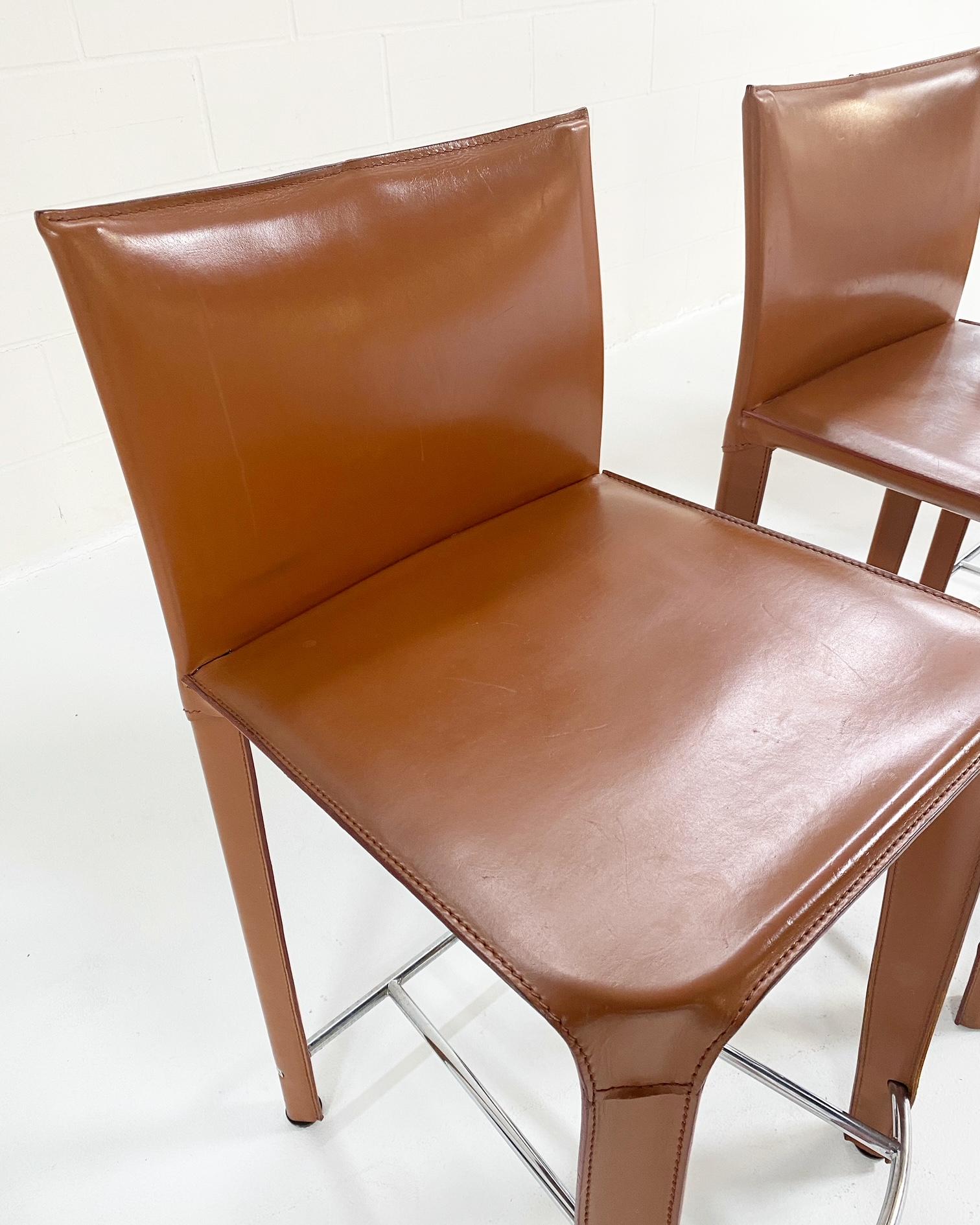 A Classic stool designed by Parisian-based manufacturer, Roche Bobois. The leather is such a great caramel color. We love the way it wraps around the piece. And a nice finish with the chrome foot plate. These are very comfortable and in great