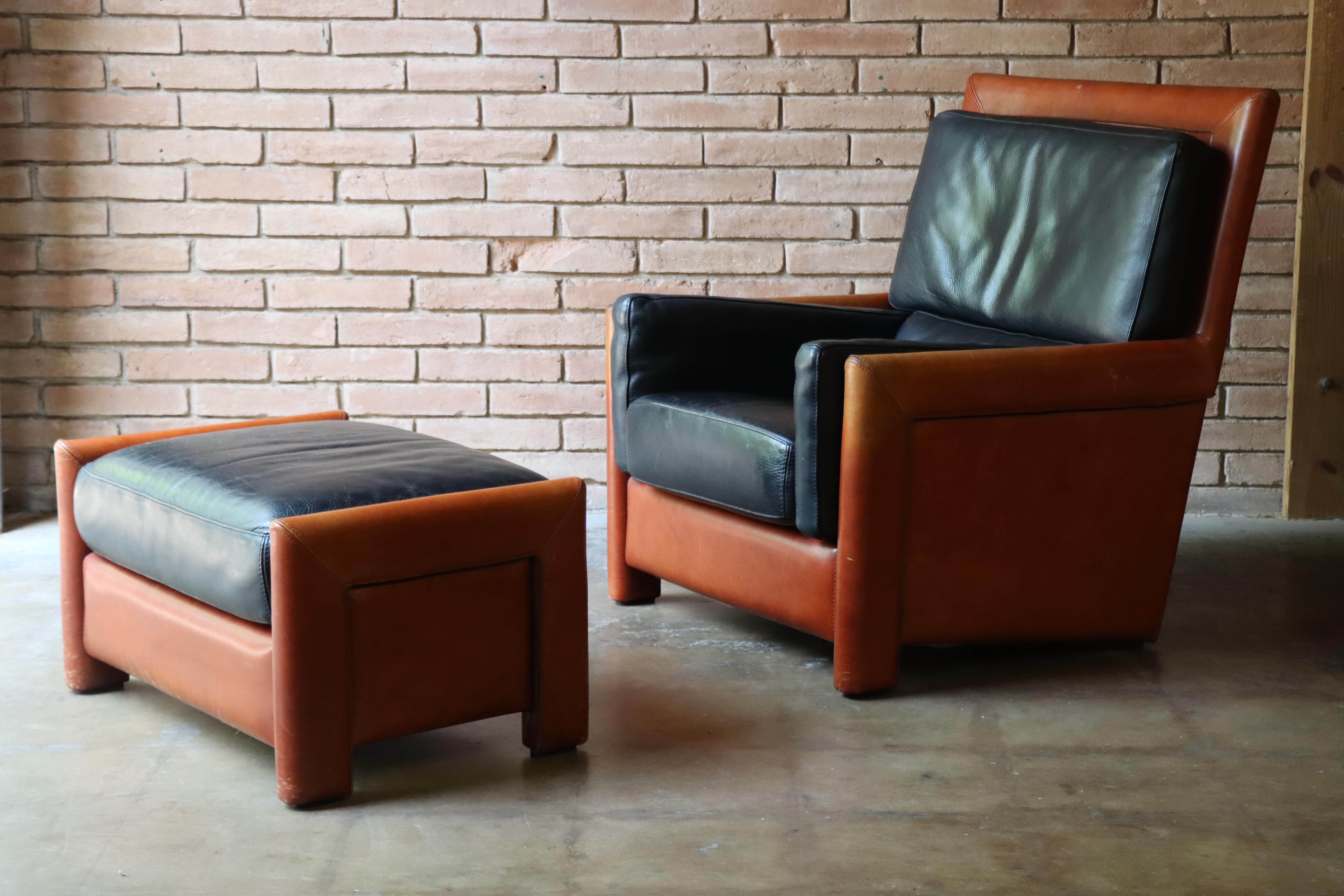 Handsome Roche Bobois (France c. 1980s) leather lounge chair and ottoman featuring a thick leather in contrasting black and cognac with visible stitch work. A very nice combination of comfort and a masculine aesthetic perfect for an office, den or