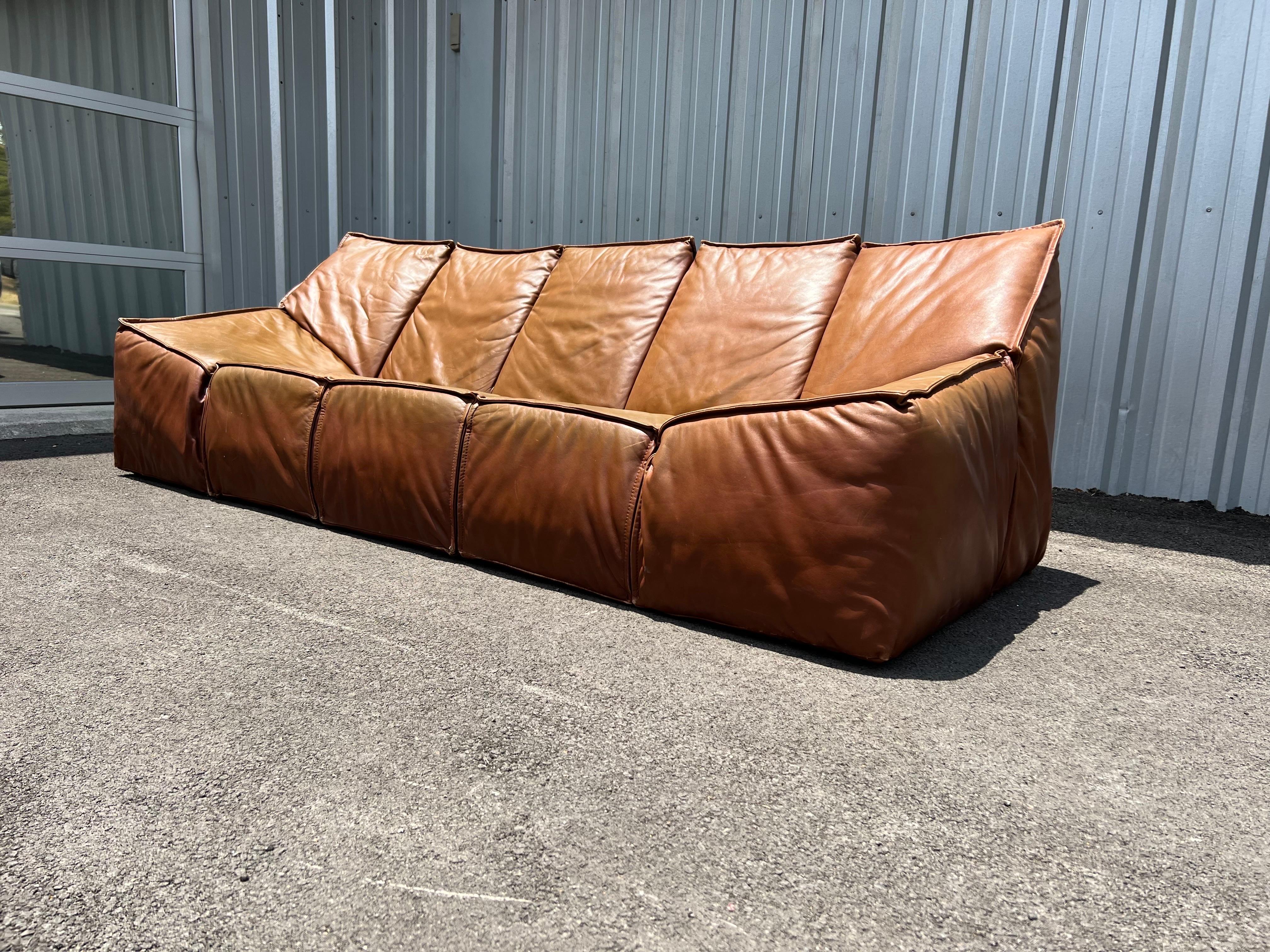 Vintage leather sofa by Roche Bobois, France, circa 1970s in cognac. This vintage sofa sits low and features a natural patina and is in good overall condition. 

Roche Bobois is a world leader in furniture design and distribution. Working closely