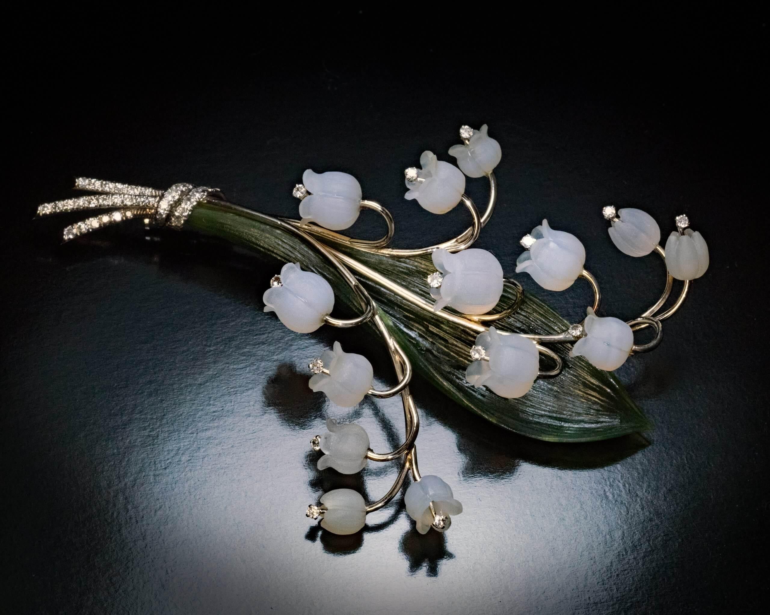 Made by Paltscho in Vienna, Austria in the 1950s.  The brooch is finely modeled as a lily of the valley. The flower heads are superbly carved from frosted rock crystal and embellished with diamonds. The green leaf is naturalistically carved from a