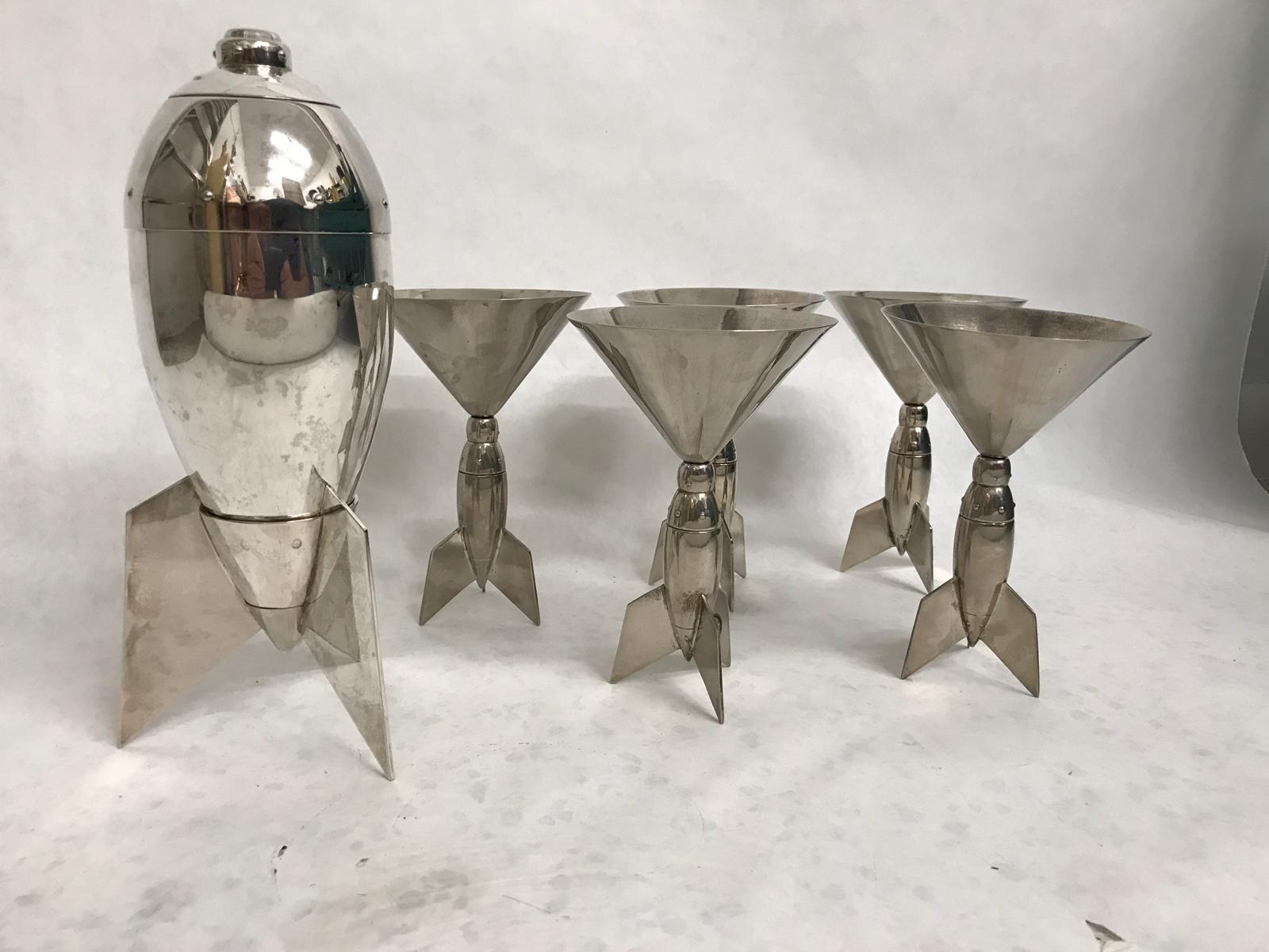 This is a beyond amazing grouping of 5 martini glasses with rocket ship design - very Cold War era and rare to find. The shaker stands on a base appearing like a rocket. Signed Godinger, very rare! Vintage and out of production.

NOTE: we also have