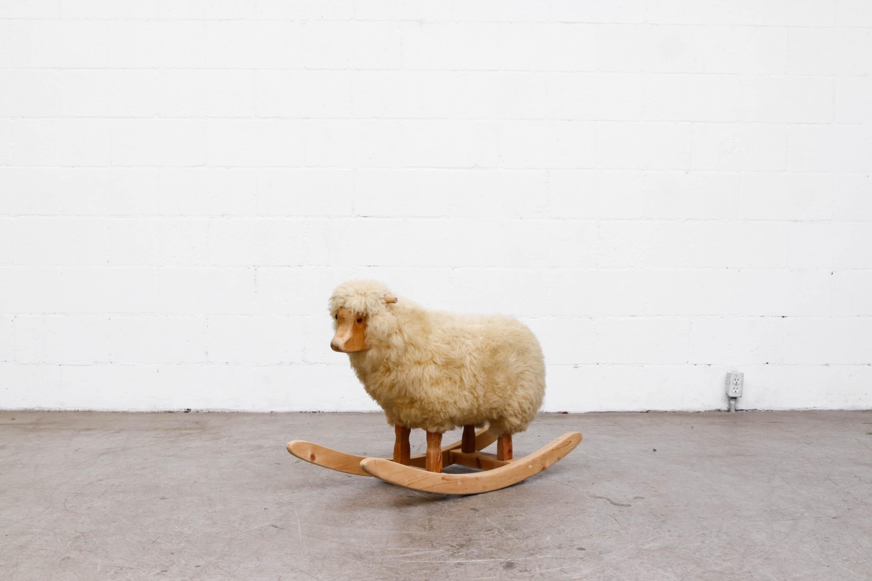 Cute rocking sheep with real sheepskin. In original condition with pine frame and handles.