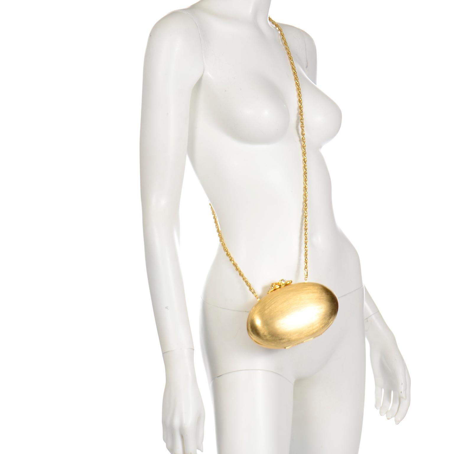 Questa bellissima borsa ovale vintage con custodia rigida in oro di Rodo ha una fodera in pelle dorata ed è stata realizzata in Italia. La cassa in oro opaco acidato è dotata di una chiusura in oro lucido impreziosita da strass. Questa può essere