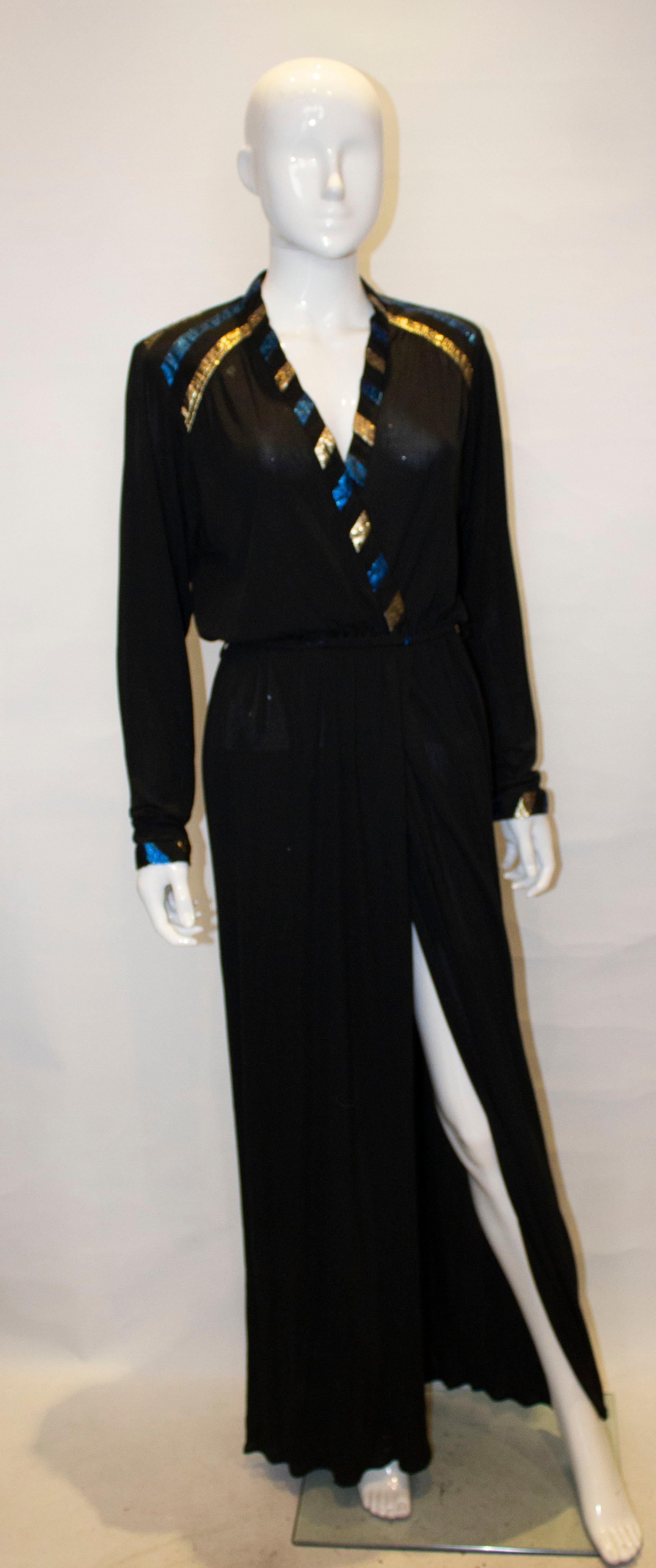 A chic and easy to wear evening dress by Roland Klein. The dress has a v neckline and wrap over front with blue and gold detail on the neck and cuffs. It has an elastic waist and slit at the front. 
Measurements : Bust 39'' waist 26'' -30'' length