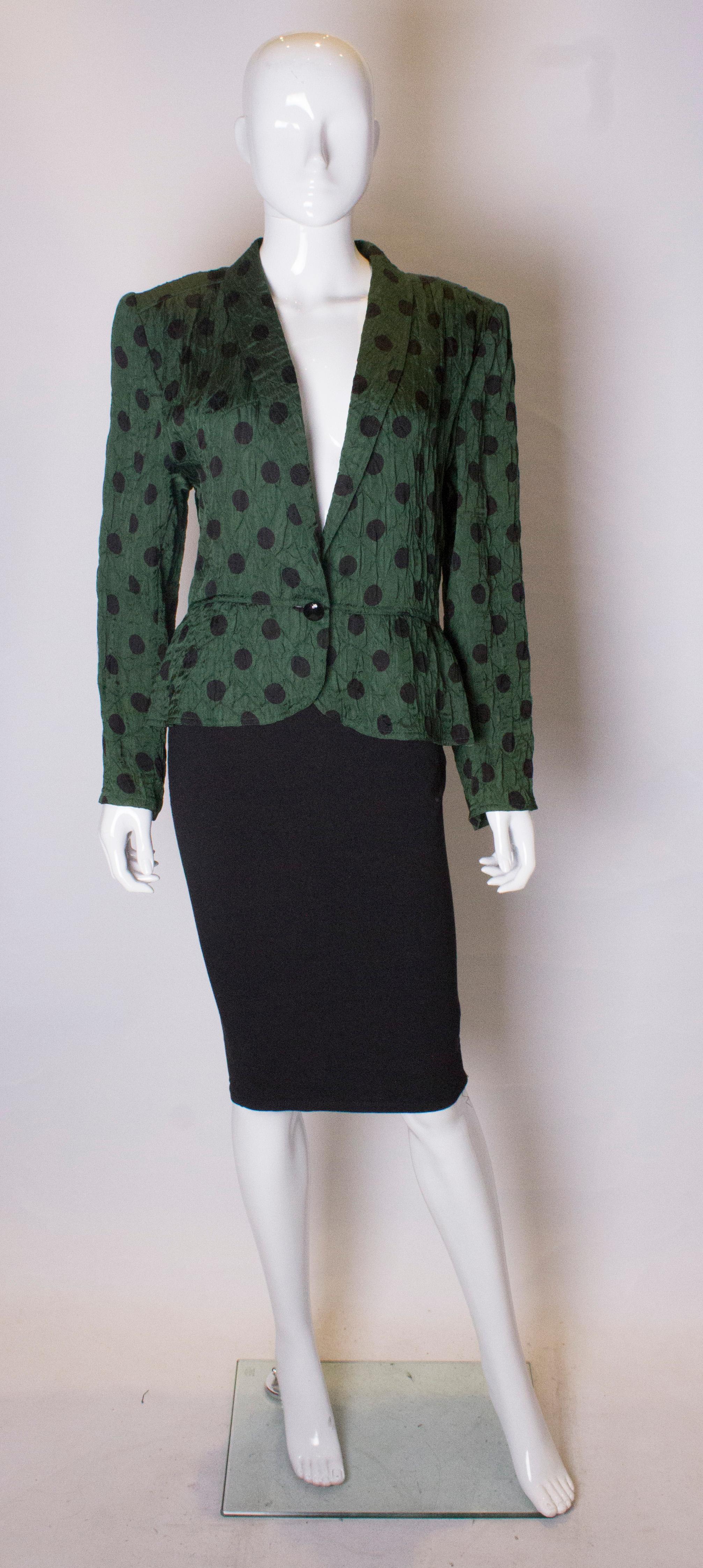 A chic jacket by Roland Klein.The jacket is in a sage green silk with black dots and a peplum. It has a shawl collar and single button fastening at waist leval.
