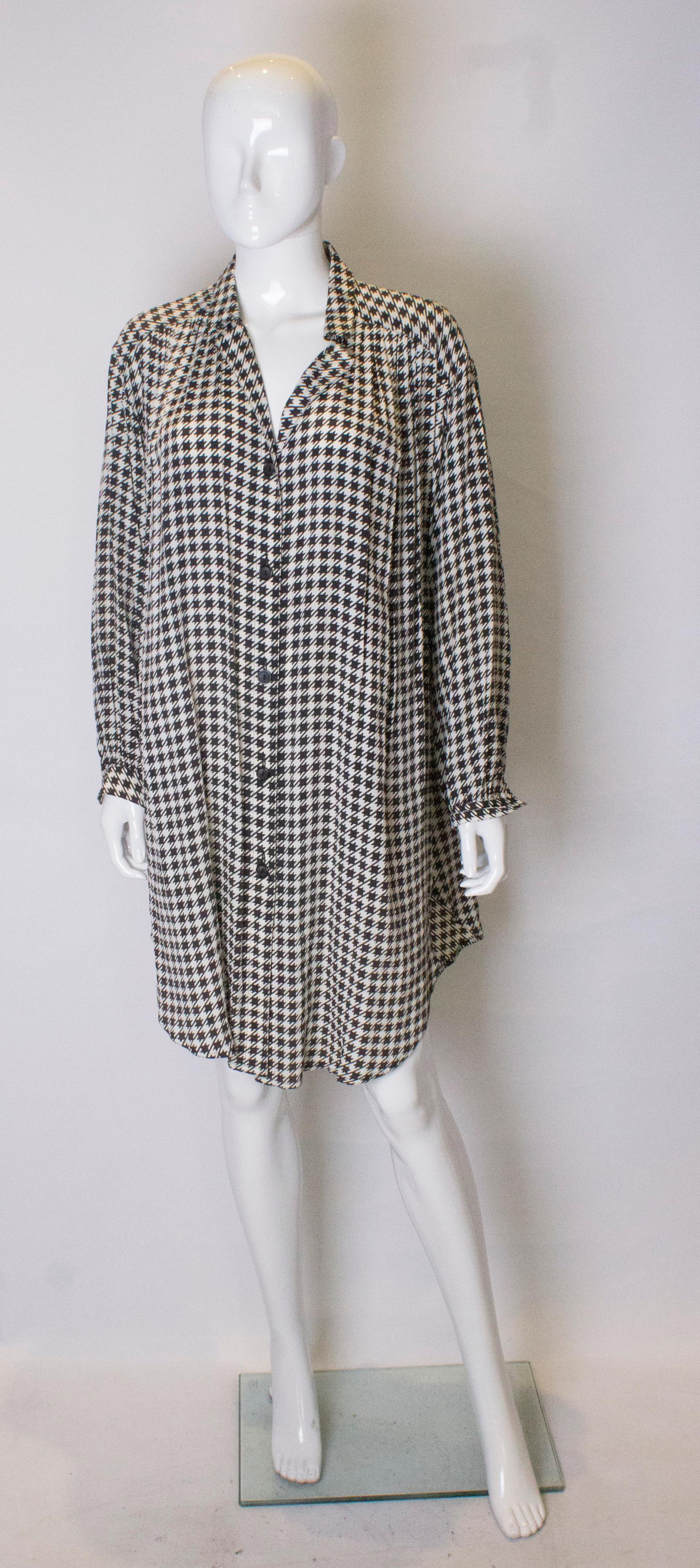 A great black and white silk overshirt by Roland Klein.
The shirt has gathering at the yoke, front and back and a 9'' slit on either side. It is loose fitting , and will fit a bust up to 48''.