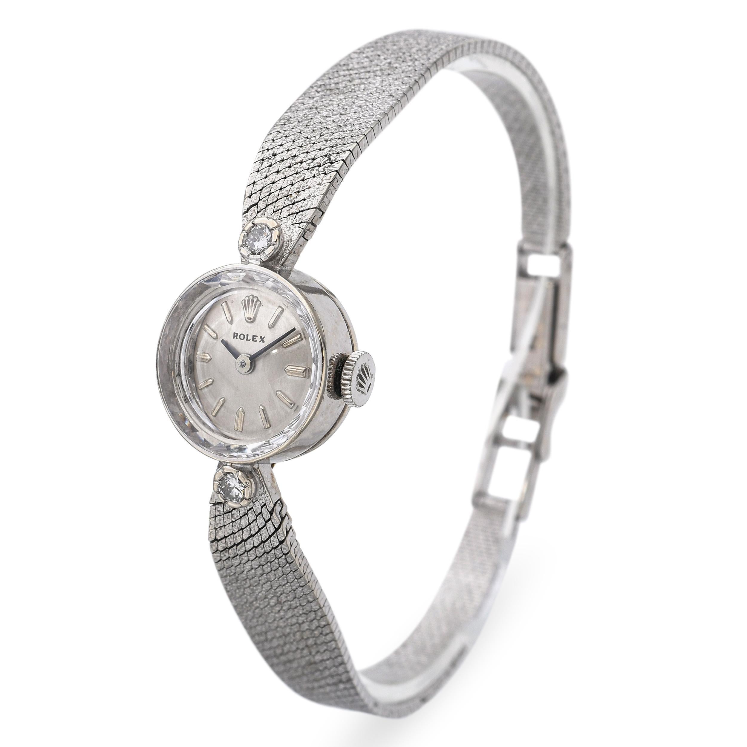 Questo squisito orologio da cocktail Rolex vintage da donna è realizzato in oro bianco 14 carati e presenta un piccolo quadrante argentato da 15 mm incorniciato da scintillanti accenti di diamanti. Il design elegante cattura il glamour di metà