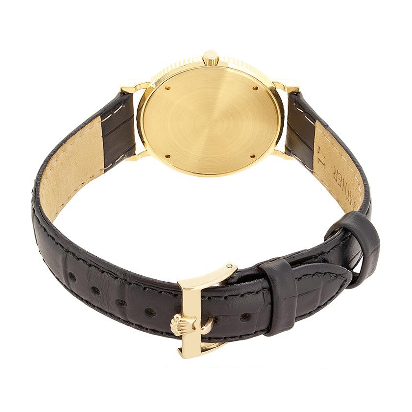 This beautiful Rolex Cellini  watch dates to the 1960s. The 18 carat yellow gold case is 32mm in diameter and features a reeded rim design. A manual winding movement makes up the heart of the watch. Chevrons denote the hour markings with the Rolex