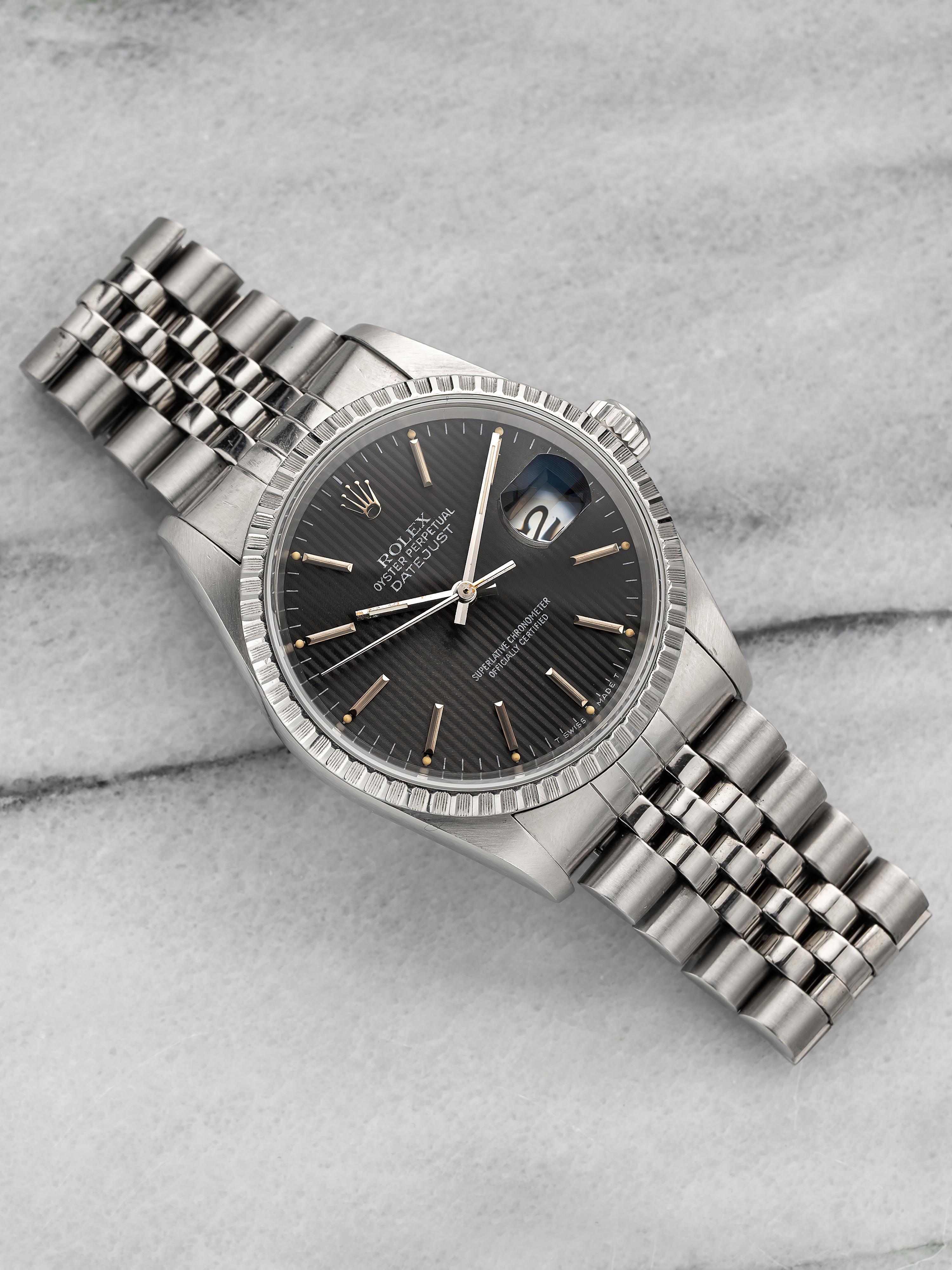 Here's a vintage Rolex Datejust reference 16220 (steel bezel) automatic with a grey tapestry dial on a jubilee bracelet from the 1990s. Recently serviced. Keeps great time and is fully functional. Measurements include a 36mm oyster case and 20mm lug