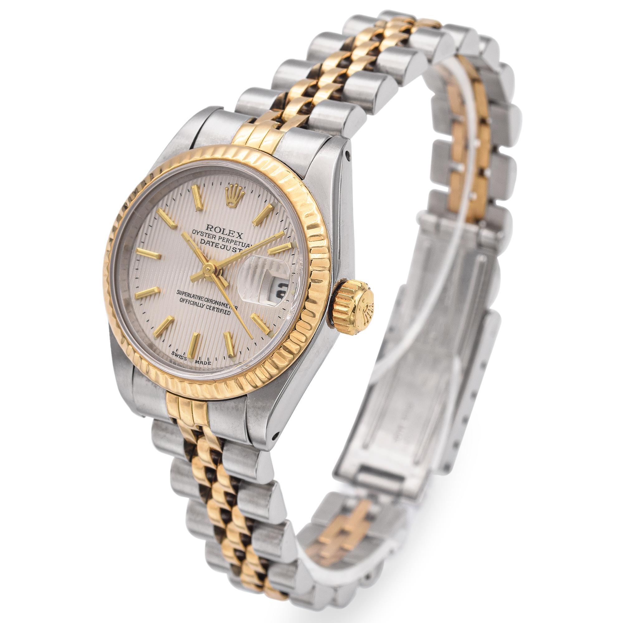 Scratch resistant sapphire crystal with cyclops magnifier.Silver tapestry dial with raised gold baton hour markers. Date calendar at 3 o'clock aperture.Stainless steel and 18k yellow gold jubilee bracelet with fold over clasp. Fits 6 1/4