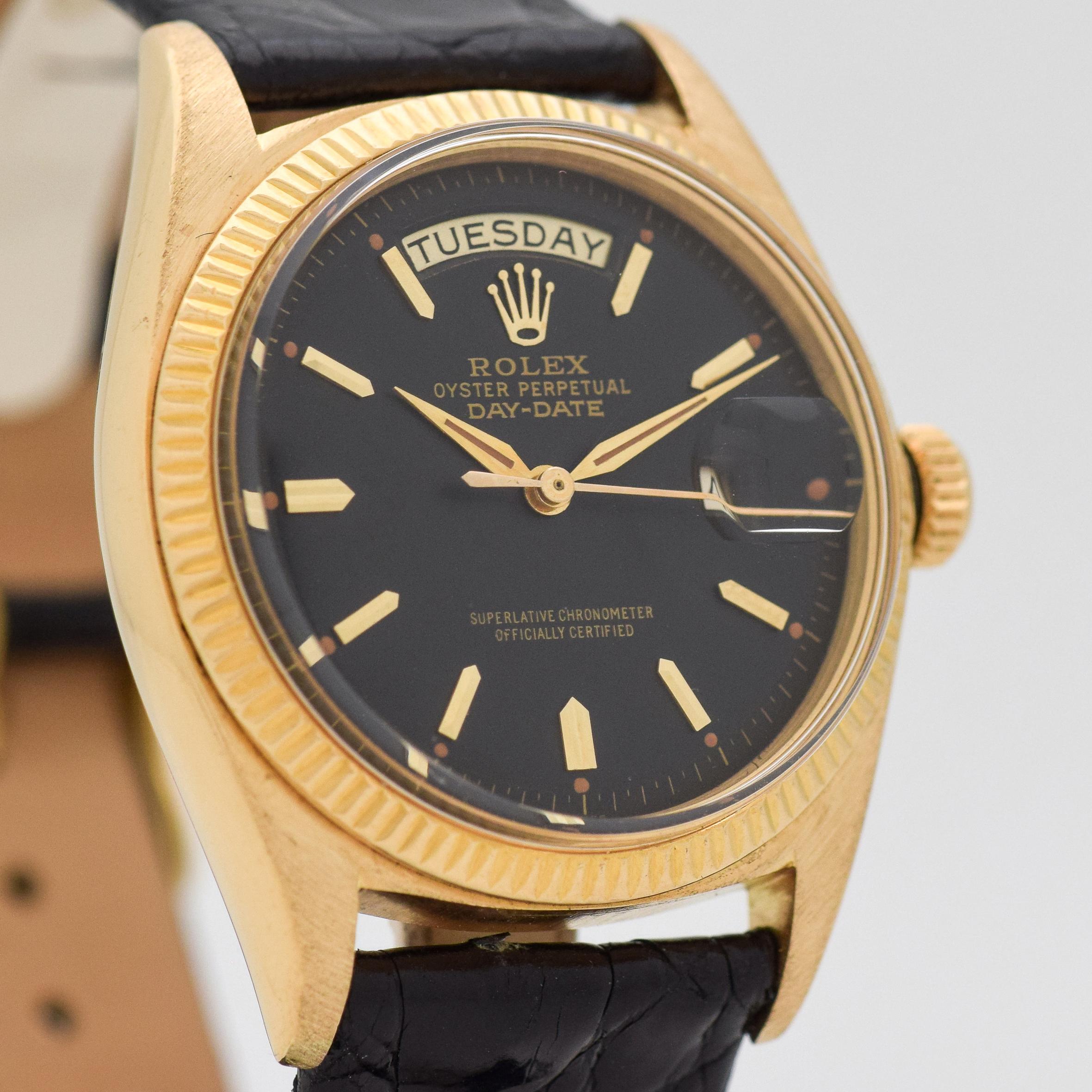 1957 Vintage Rolex Day-Date President Reference 1803. 18K Yellow Gold case. Original, but restored black dial. 36mm wide. Powered by a 25-jewel, automatic caliber movement. Equipped with a Glossy, Black-Colored Crocodile Watch Strap. Triple Signed.