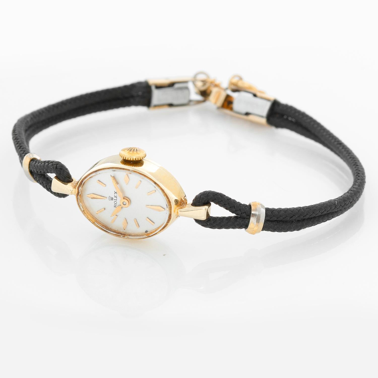 Vintage Rolex Ladies Dress Watch - Manual winding. 14K Yellow gold ( 12 x 18 mm ). Silver dial with raised index. Black double rope bracelet; will fit a 6 1/2 inch wrist. Pre-owned with custom box .