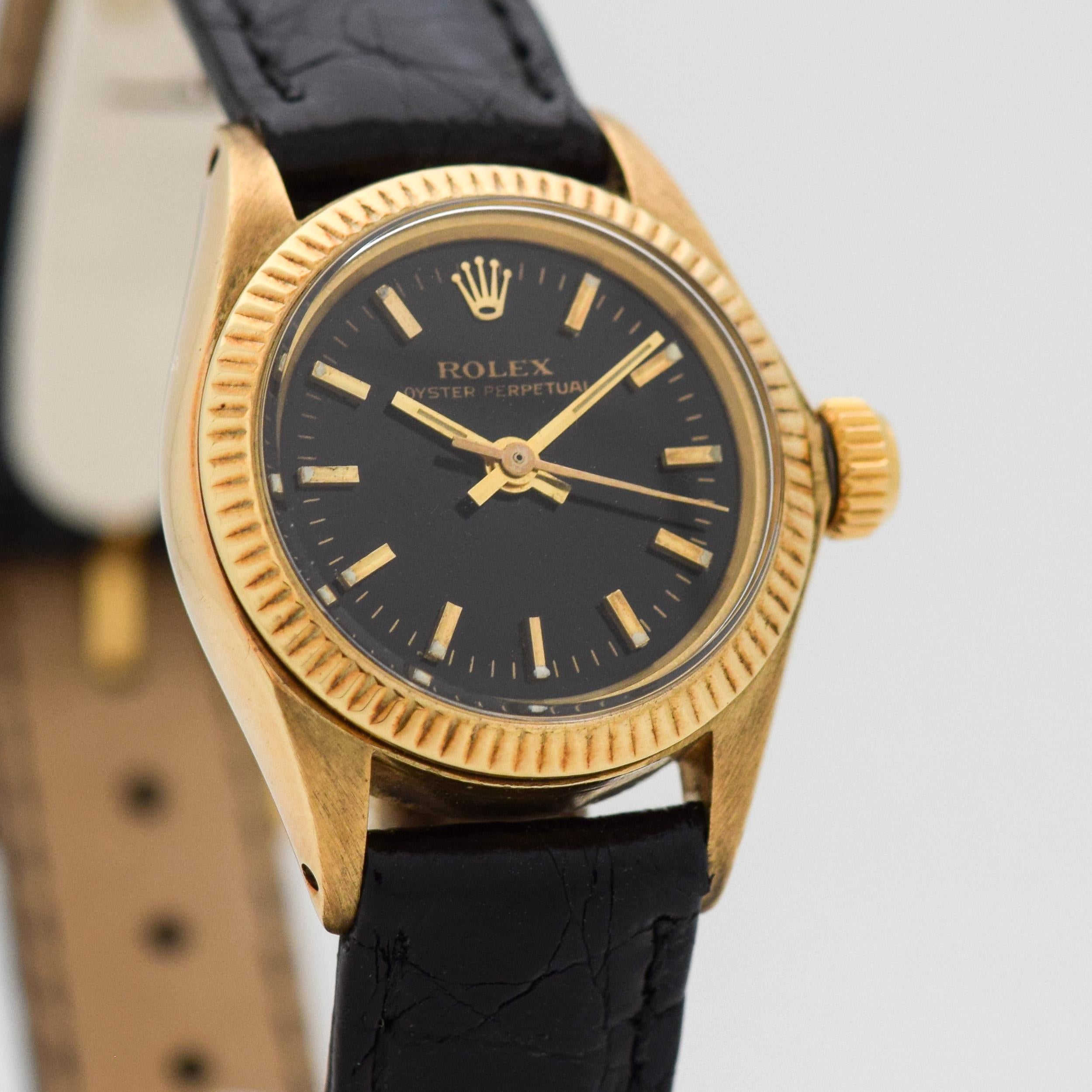 1978 Vintage Rolex Ladies Oyster Perpetual Ref. 6917 14k Yellow Gold watch with Black Dial with Applied Yellow Gold Baton/Bar Markers. 25mm x 31mm lug to lug (0.98 in. x 1.22 in.) - Powered by a 28 jewel, automatic caliber movement. Triple Signed.