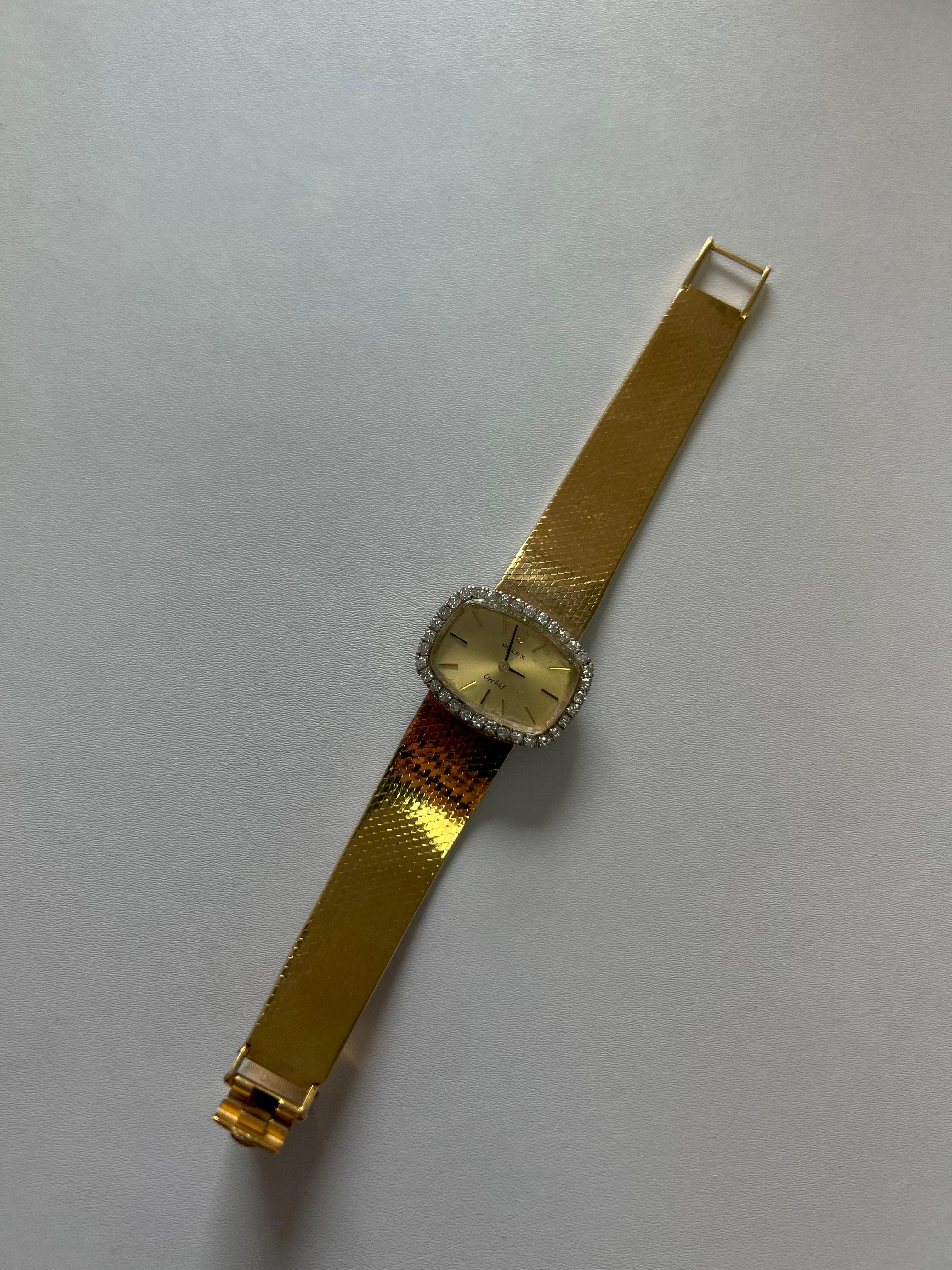 Rolex Orchid Diamonds - 6.1 inches length - 18K Yellow Gold - 53.8 Grams
Circa 1975 Rolex Orchid, part of Rolex’s series of cocktail watches.
u.	Case Width: 25mm
v.	Crystal: Sapphire
w.	Watch Movement: Rolex caliber 1400 manual wind
x.	Band: 18K
