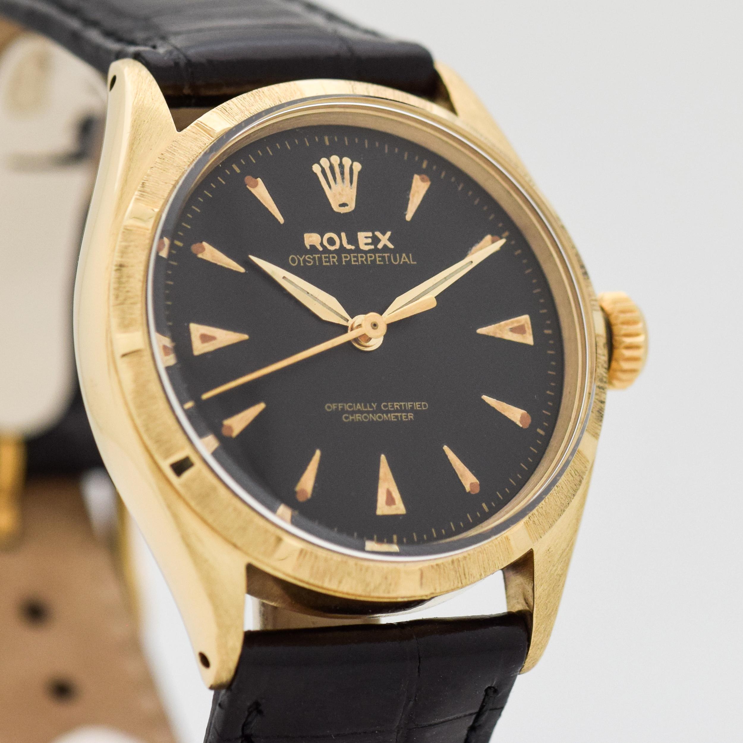 1952 Vintage Rolex Oyster Perpetual Reference 6285. 14K Yellow Gold case. Machined bezel. 34mm wide. Original, but restored black dial with arrow markers. Powered by an 18-jewel, automatic caliber movement. Featured on a Genuine Alligator Glossy