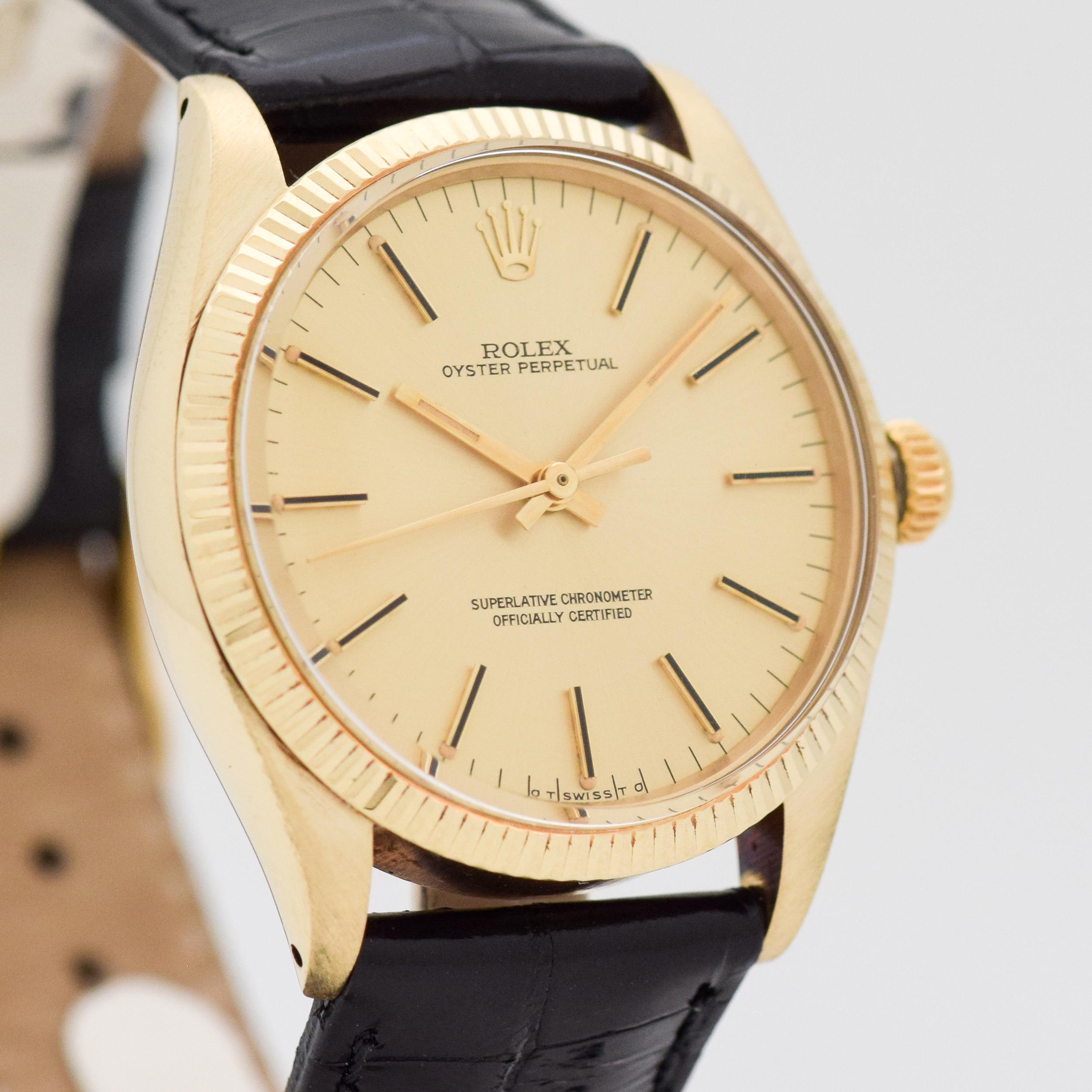 A 1976 Vintage Rolex Oyster Perpetual Reference 1005. 18K Yellow Gold Watch case. 34mm wide. Original, champagne dial. Equipped with a 26-jewel, automatic caliber movement. Comes on a Glossy, Black-colored Genuine Alligator watch strap. Swiss-made.