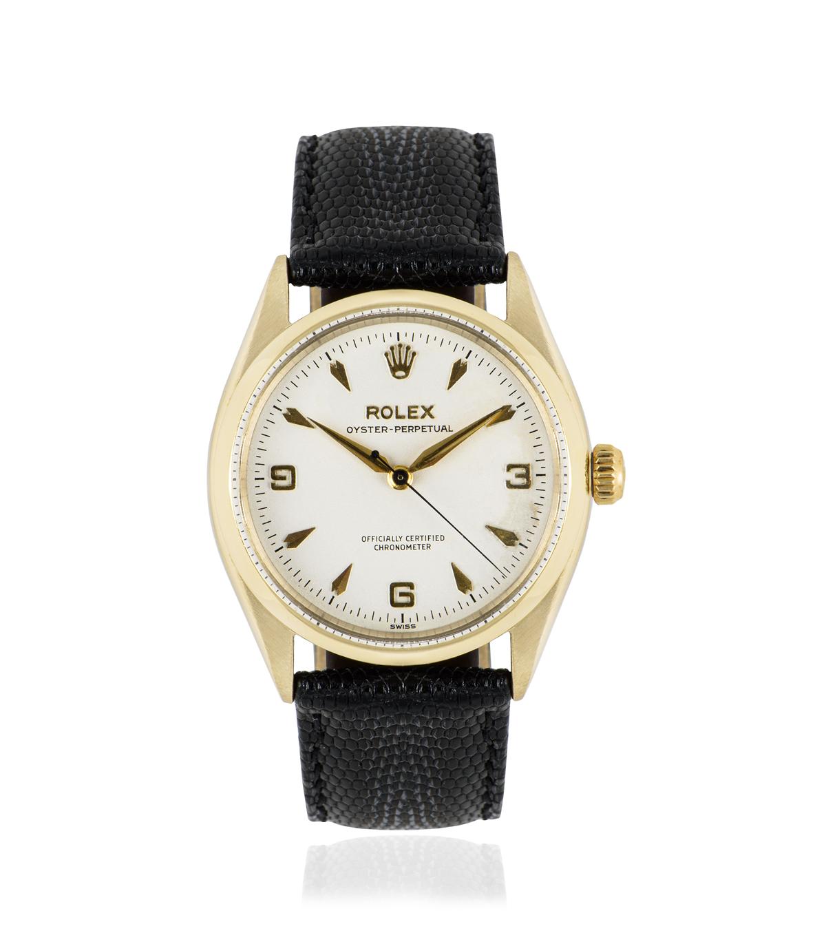 This 34 mm 9k yellow gold vintage Oyster Perpetual by Rolex is in fine condition. Features a silver dial with dagger style hour markers and Arabic numbers 3, 6 and 9. A generic black leather strap comes with a Rolex gold plated pin buckle. Fitted