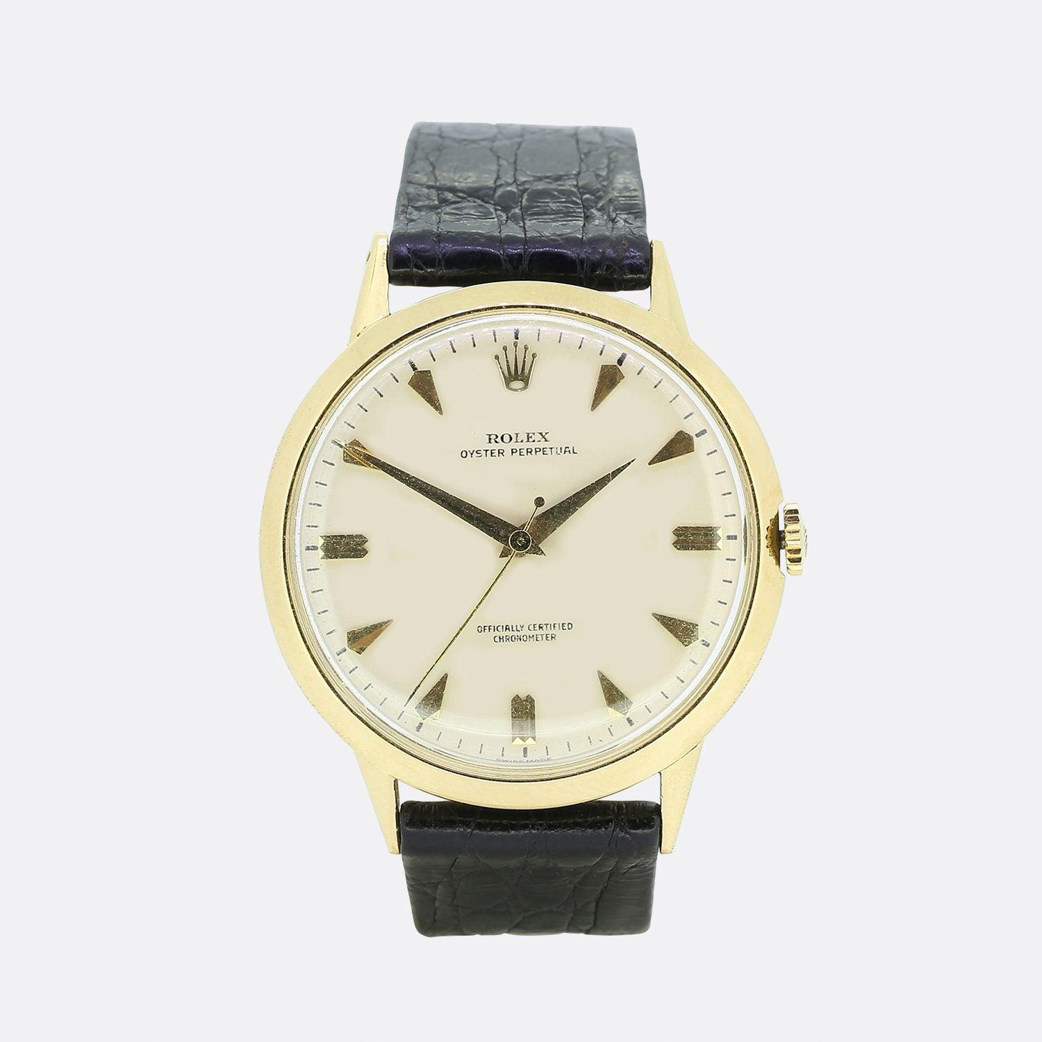 This is a Vintage 18ct yellow Rolex Oyster Perpetual watch. The watch has an 18ct yellow gold case, a cream dial with gold hour markers and the Rolex crown at 12 o'clock. The watch features all its original parts and the Rolex logo can be seen on