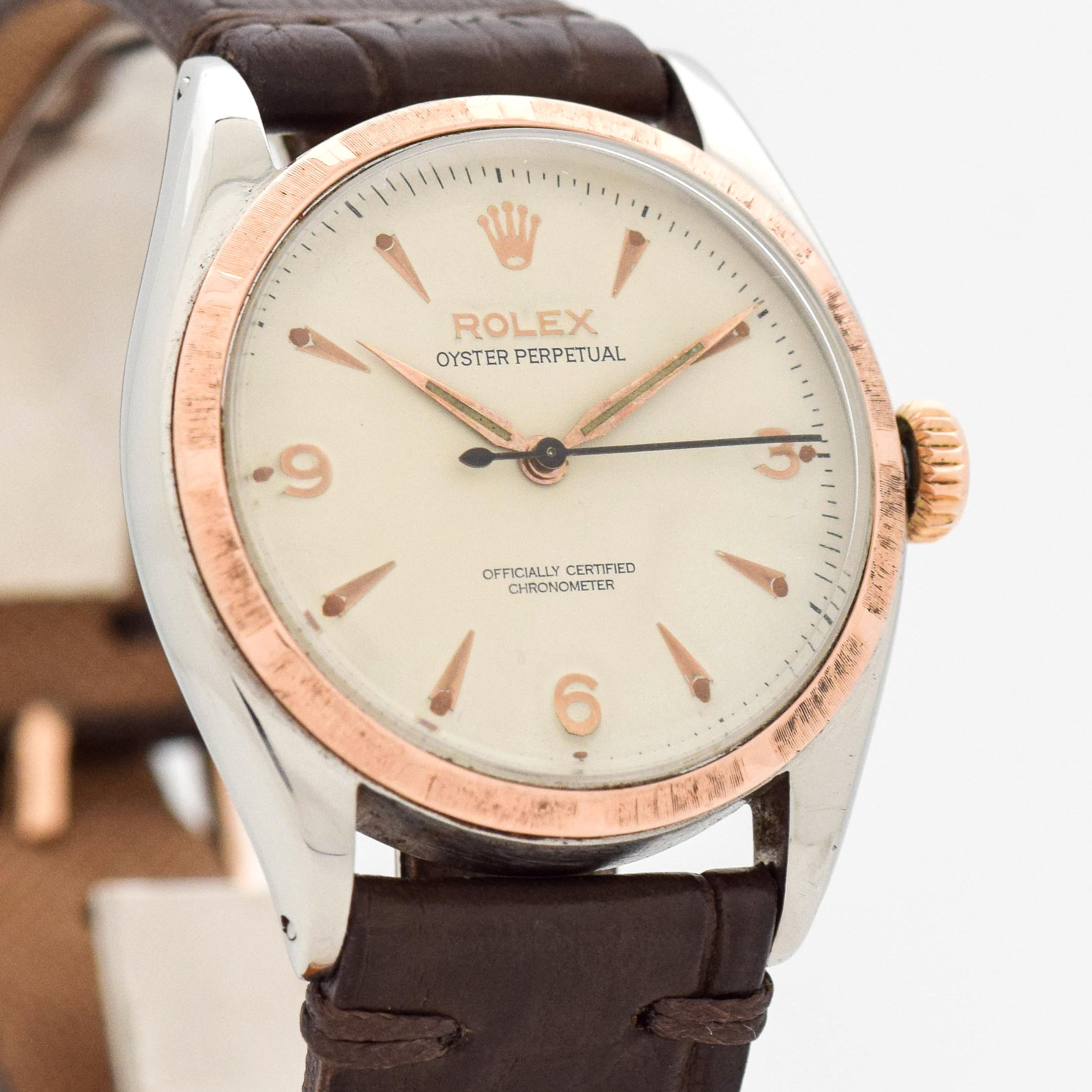 1953 Vintage Rolex Oyster Perpetual VERY EARLY Ref. 6085 Two Tone 14k Rose Gold Machined Bezel and Stainless Steel Case watch with White Dial with Applied Rose Color Arabic 3, 6, and 9 with Elongated Beveled Arrow Markers. 34mm x 39mm lug to lug