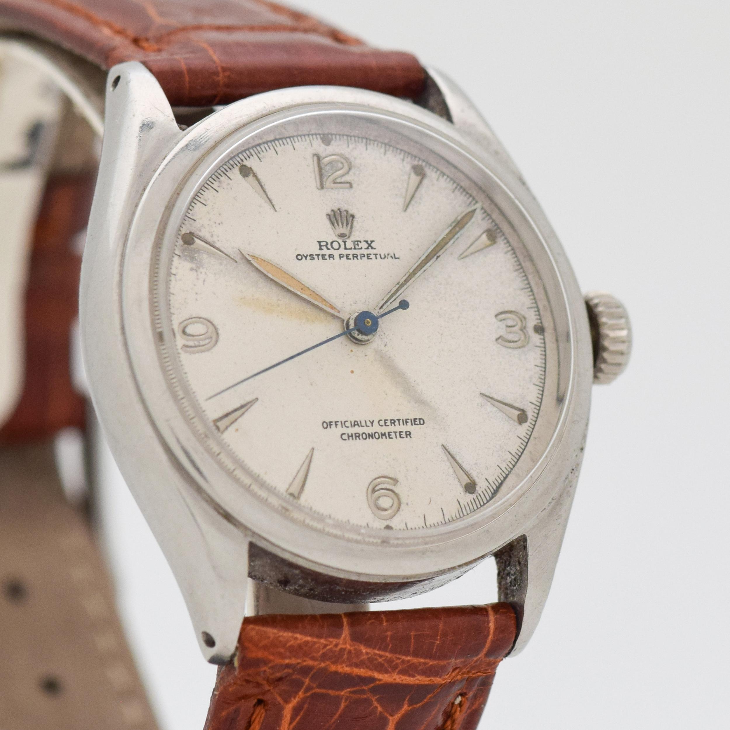 1952 Vintage Rolex Oyster Perpetual Ref. 6084 Stainless Steel watch with Silver Dial with Applied Steel Arabic 3, 6, 9, and 12 Plus Elongated Arrow Markers. 34mm x 38mm lug to lug (1.34 in. x 1.5 in.) - 17 jewel, automatic caliber movement. Triple