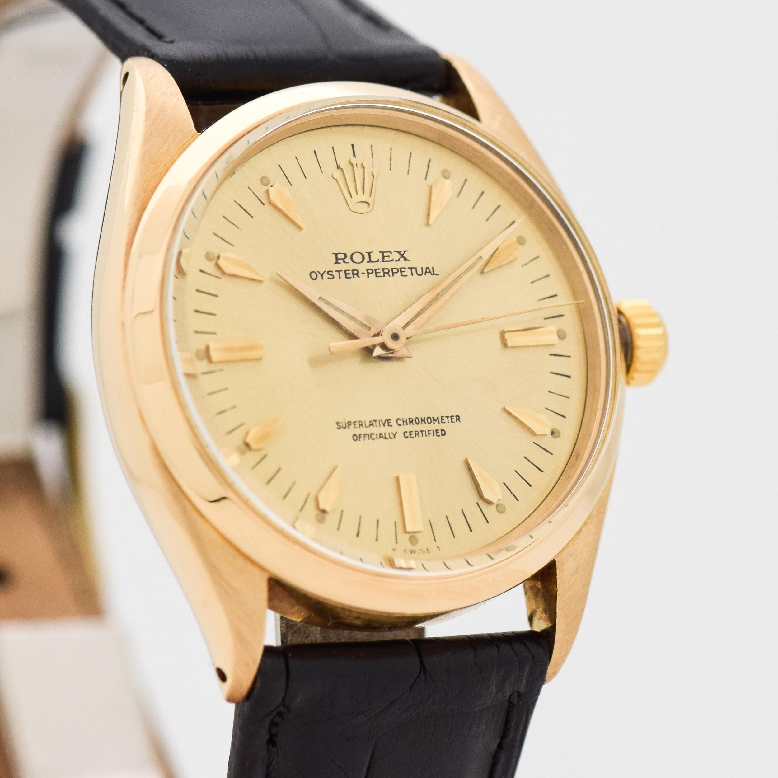 1955 Vintage Rolex Oyster Perpetual Ref. 6564 18k Yellow Gold Case Officially Certified Chronometer watch with Gold/Champagne Dial with Applied Gold Beveled Elongated Arrow and Beveled Bar/Baton Markers. 34mm x 38mm lug to lug (1.34 in. x 1.5 in.).