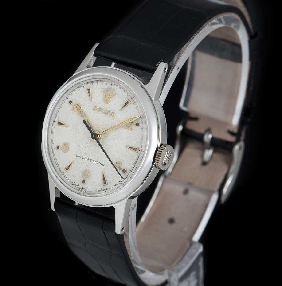 A Stainless Steel Shock Resisting Vintage Gents Wristwatch, white dial with applied hour markers and applied arabic numbers at 2,4,6,8 and 10, a fixed stainless steel smooth bezel, a black leather strap with a stainless steel pin buckle (both not by