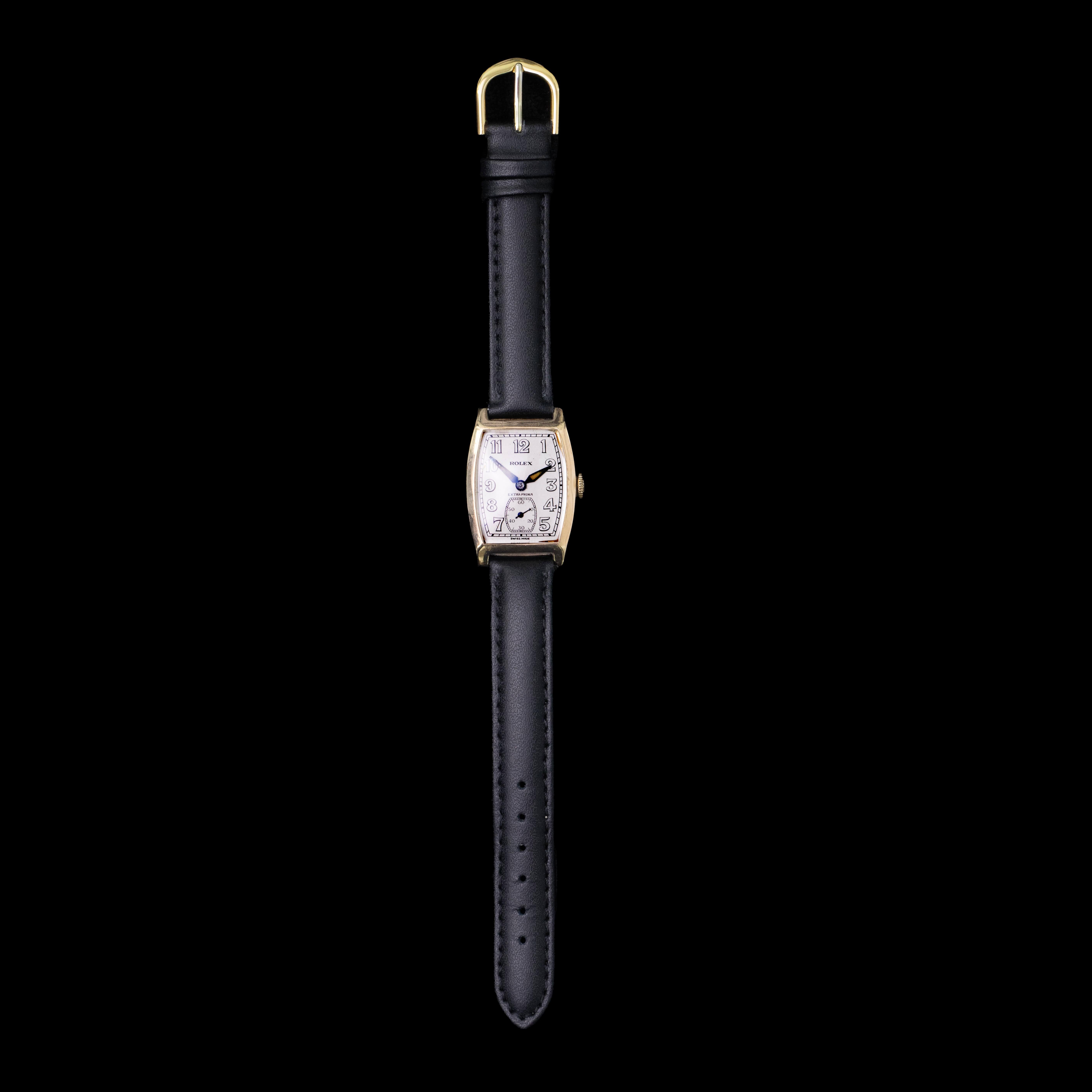 Un orologio da polso Rolex Extra Prima vintage degli anni '30 realizzato in oro rosa 9 carati con un moderno cinturino in pelle nera. Questo orologio svizzero è in ottime condizioni e presenta il quadrante originale in argento con dettagli numerici
