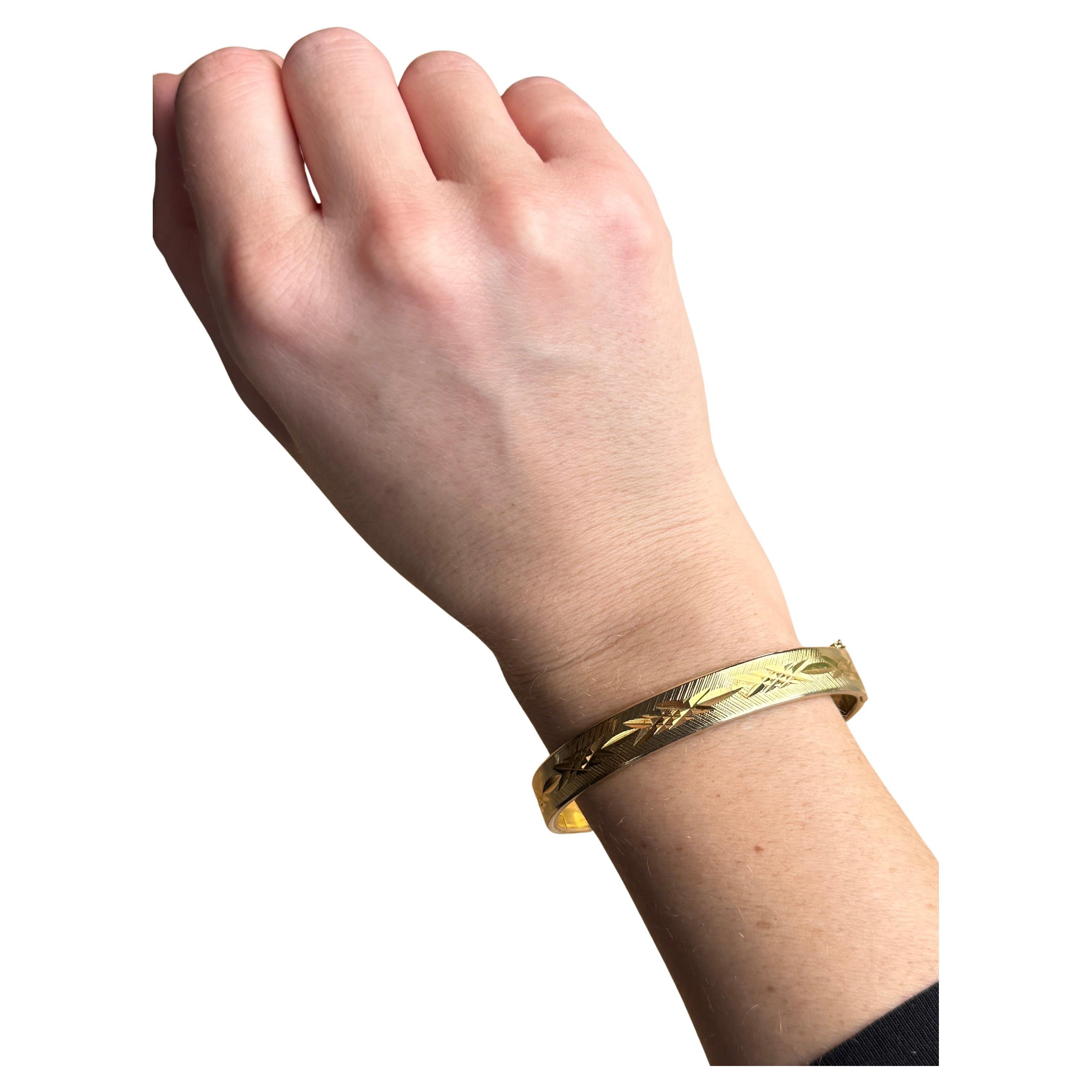 Dieser wunderschöne Armreif aus 18 Karat Walzgold hat eine wunderschöne Gravur. Walzgold bedeutet, dass es sich um einen Metallkern handelt, der mit einer feinen Schicht aus 18-karätigem Gold überzogen ist. 

Innerer Umfang:  18cm
Armreif Breite: