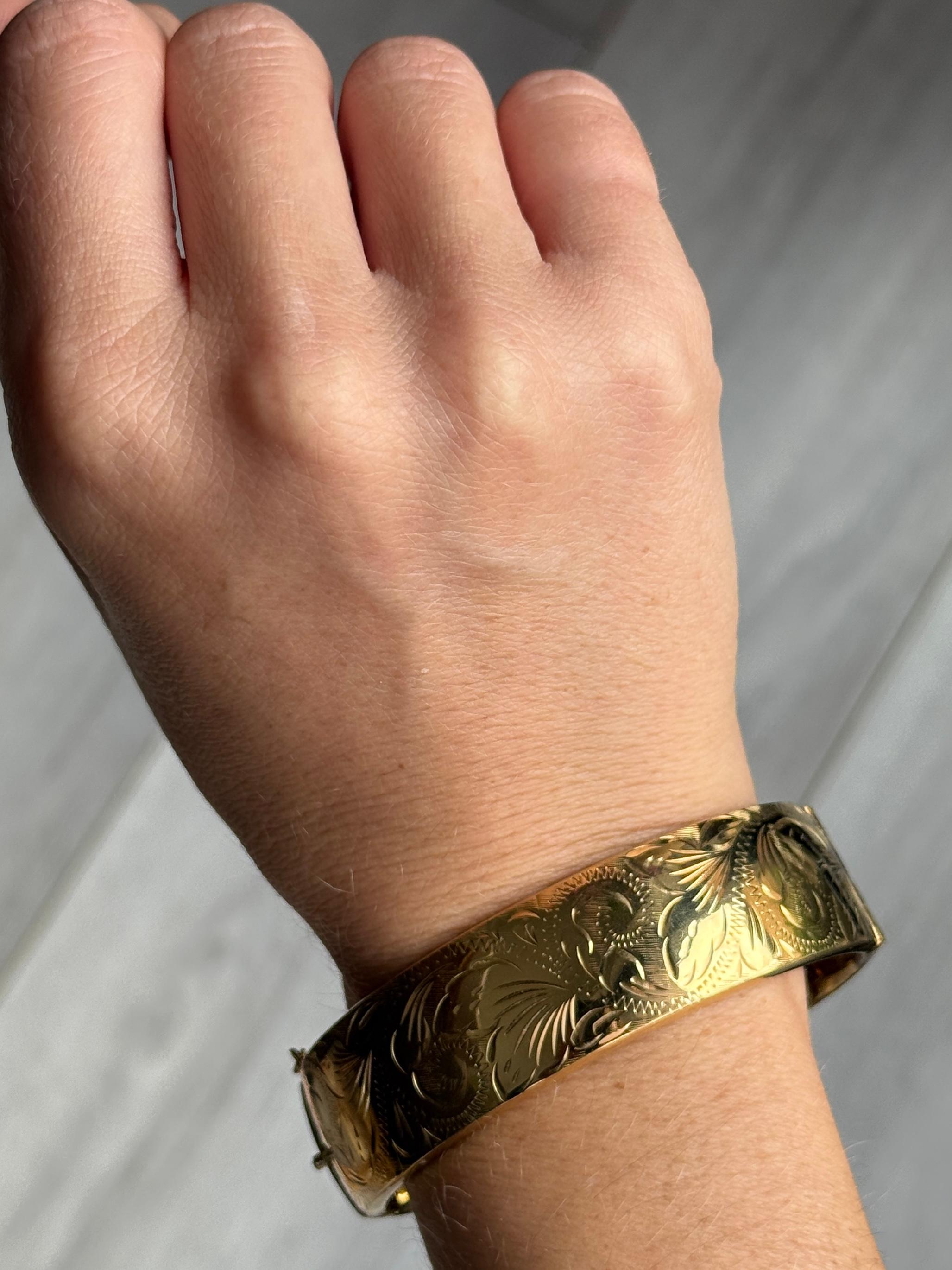 Dieser wunderschöne Armreif aus Walzgold hat eine wunderschöne Gravur. Walzgold bedeutet, dass es sich um einen Metallkern handelt, der auf der Oberseite mit einer feinen Goldschicht überzogen ist. 

Innerer Umfang:  18cm
Armreif Breite: