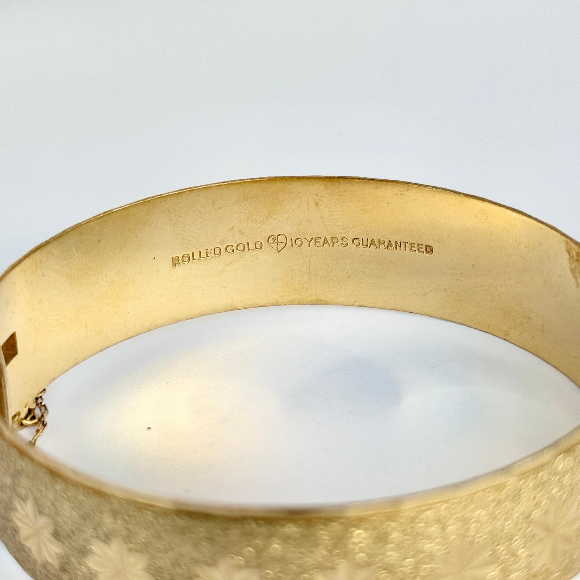 Dieser wunderschöne Armreif aus Walzgold hat eine wunderschöne Gravur. Walzgold bedeutet, dass es sich um einen Metallkern handelt, der auf der Oberseite mit einer feinen Goldschicht überzogen ist. 

Innerer Umfang:  17.5cm
Innendurchmesser