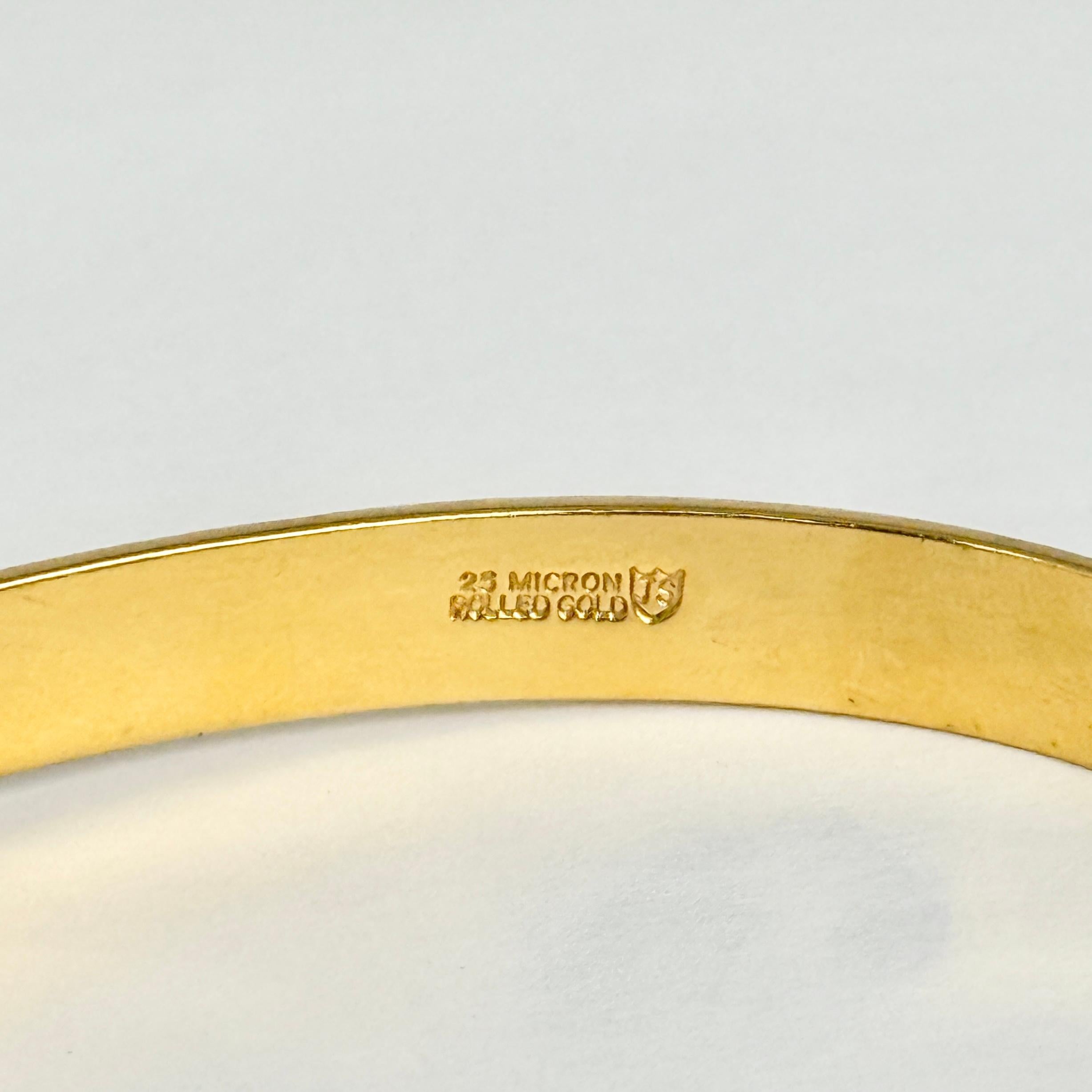 Dieser wunderschöne Armreif aus Walzgold hat eine wunderschöne Gravur. Walzgold bedeutet, dass es sich um einen Metallkern handelt, der auf der Oberseite mit einer feinen Goldschicht überzogen ist. 

Innerer Umfang: 17,8 cm
Innendurchmesser