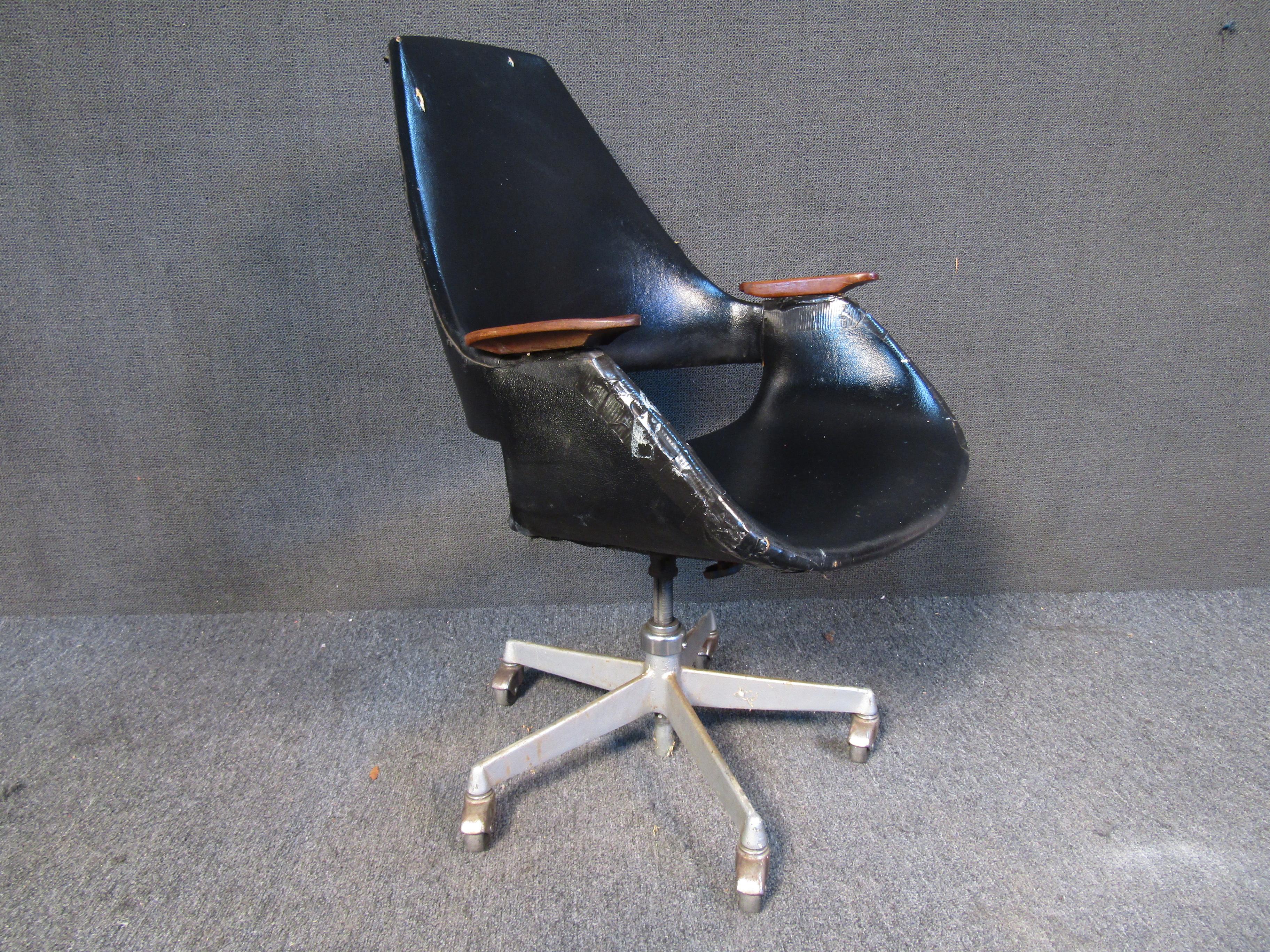 This vintage rolling office chair combines black vinyl upholstery with wooden armrests and a swiveling base. Please confirm item location with seller (NY/NJ).