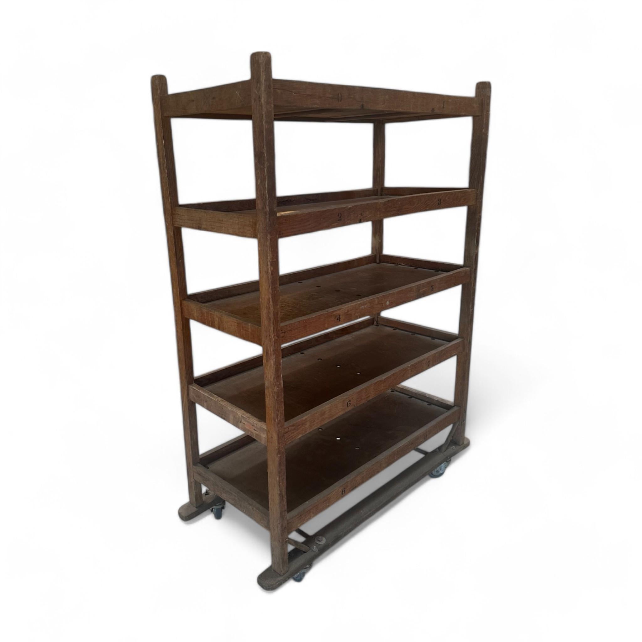Estantería rodante vintage de madera con estantes numerados - Una pieza atemporal perfecta para almacenar o exponer, con resistentes estantes de madera con encantadores detalles numerados y ruedas de desplazamiento suave para facilitar su movilidad.