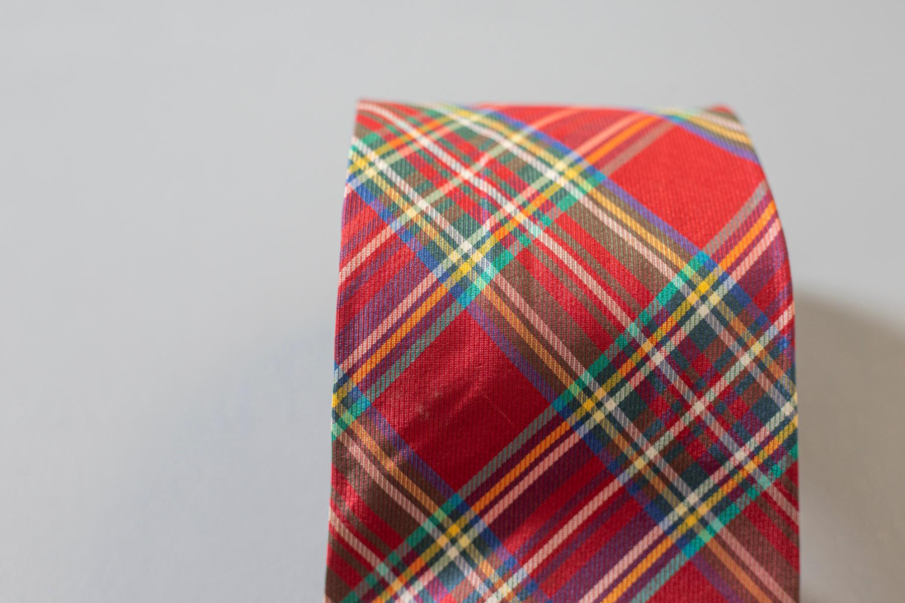 Colorful and showy, this italian tie was designed by Romeo, 100% silk which is the reason why it is smooth and of good quality. Decorated with jacquard plaid motif predominantly in red with small lines in green and blue. this accessory is perfect