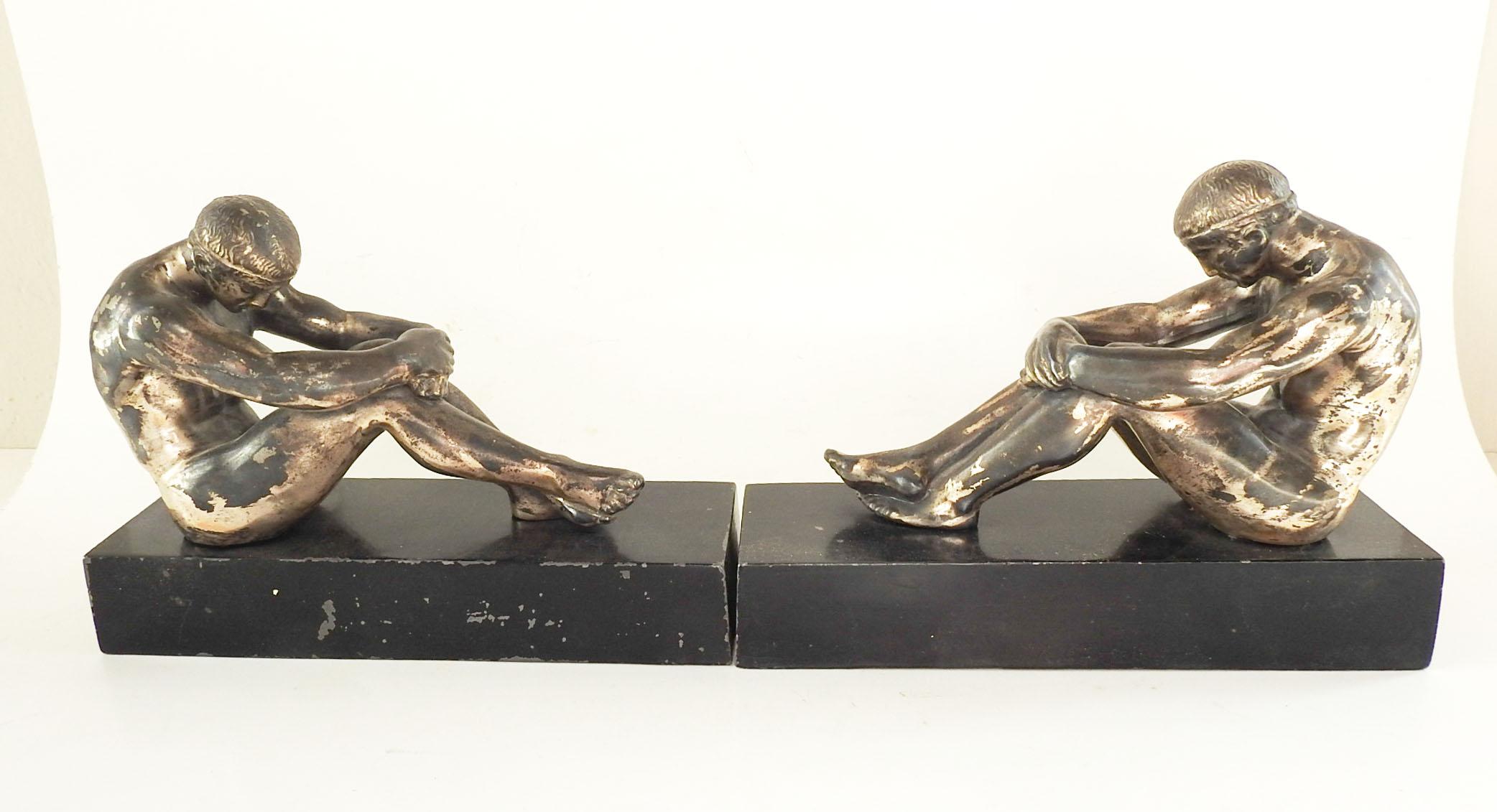 Paire de serre-livres en métal Ronson Art, datant des années 1920. Athlètes grecs sur socle noir avec patine argentée sur les figures. Fond en feutre avec autocollant d'origine, éraflures sur les bases.