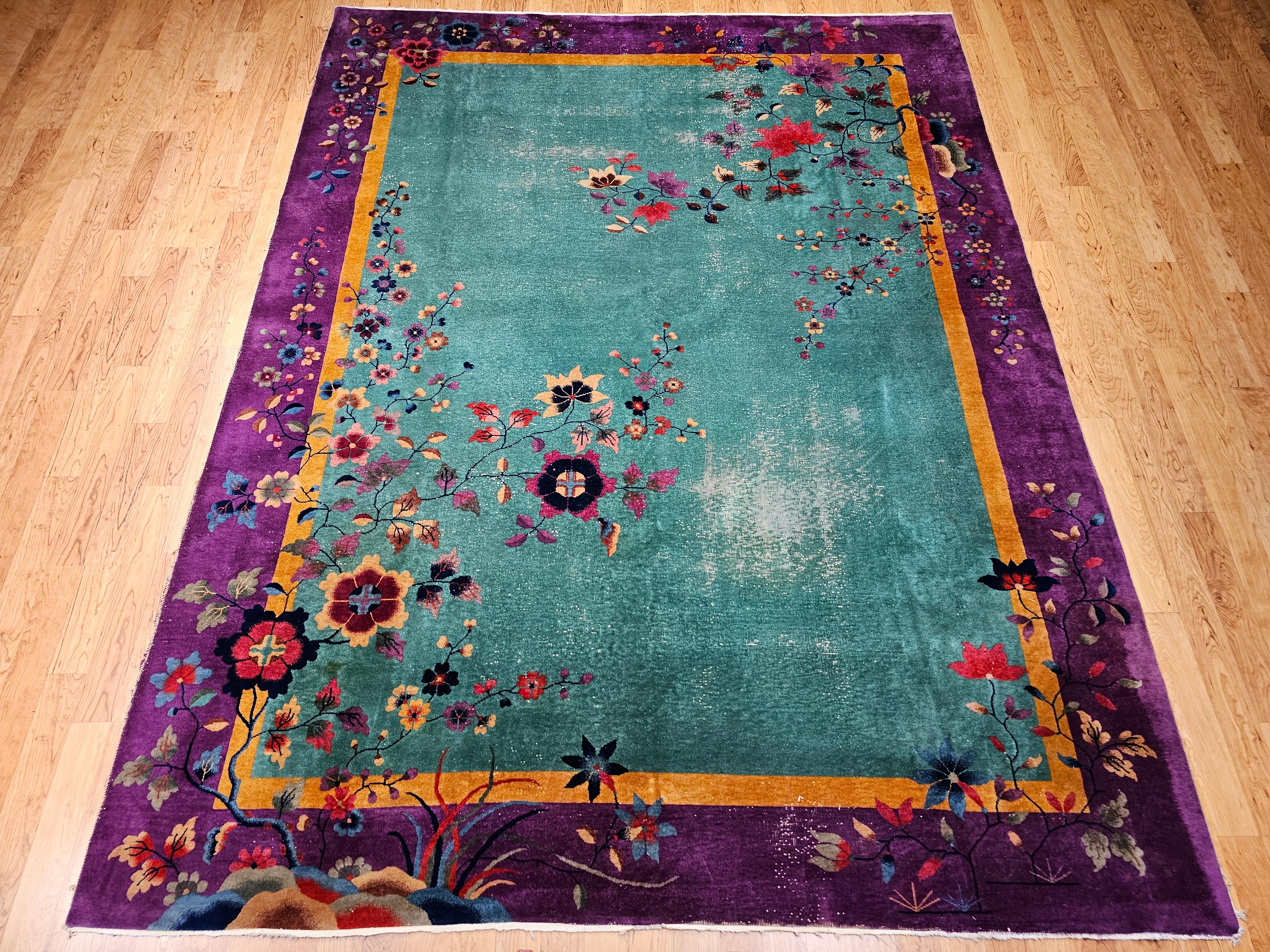 A vibrant expression of early 20th-century Chinese Art Deco design, this hand-knotted rug features a serene green field framed by a rich purple border, setting the stage for a lush and lyrical bird and floral motif.
Delicate blooms and perched birds